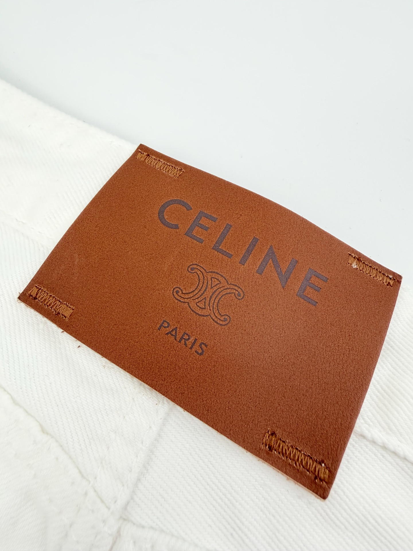 Celine 定制高密定织本白丹宁布 质感卓越 舒适贴肤 以温润柔和的奶感白调为基调 醇厚干净 一枚Celine皮牌于后腰留白处悄然点缀格调 低调显贵 以纯粹净白为设计内核 简约却极具辨识度 自带清冷松弛的老钱氛围感 行走间自有一番随性自在的气度