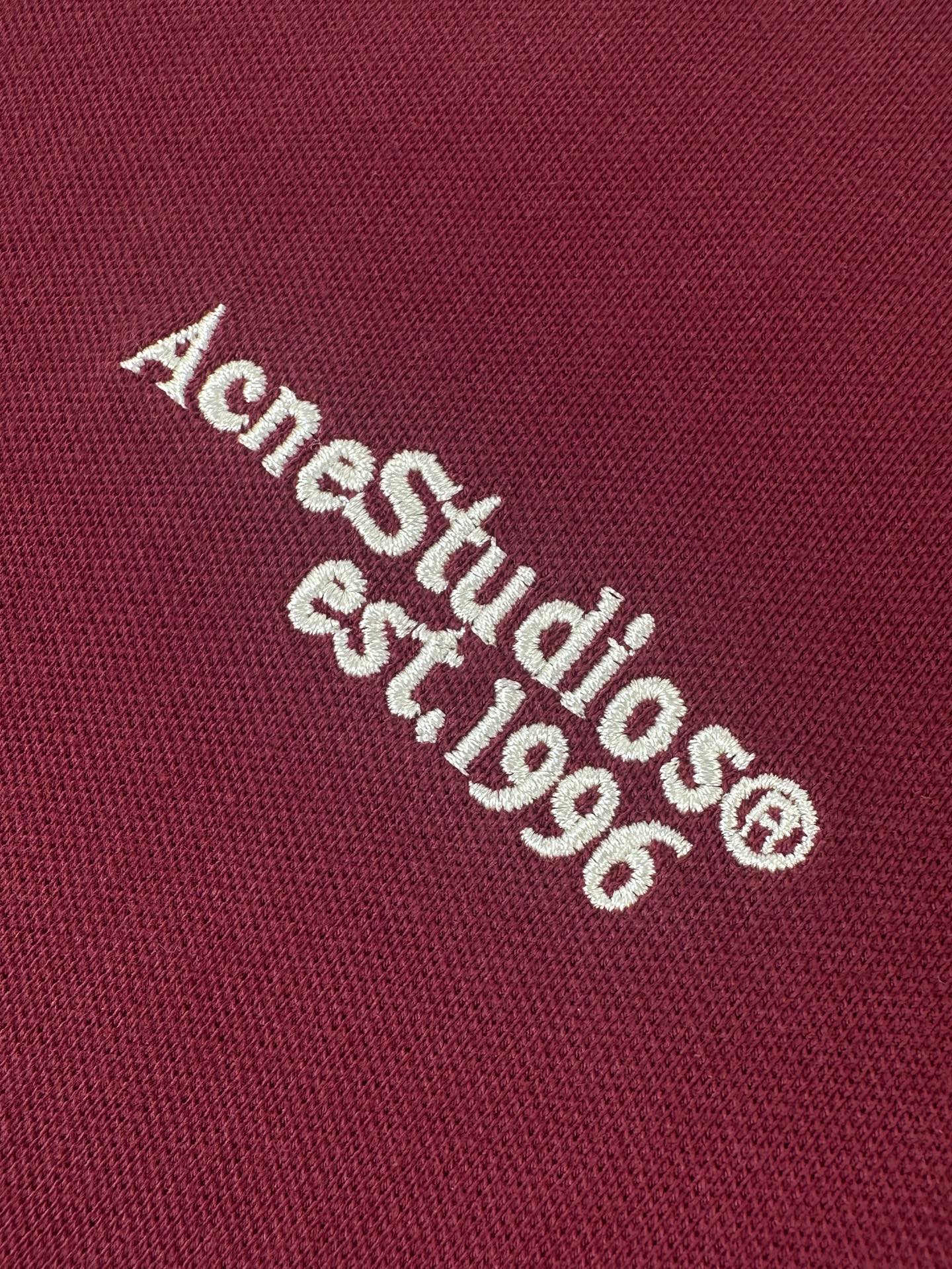 Acne Studios 定制绒壤有机棉 细腻柔软 温润亲肤 岁月沉淀的砖红做旧色 肌理间漫溢克制而隽永的贵气 一枚Acne Studios 徽标 轻落于左胸之上 于低调处镌刻品牌基因 极简却掷地有声 Polo廓形承托日常 徽标细节点亮格调 于简约中 见奢华真意