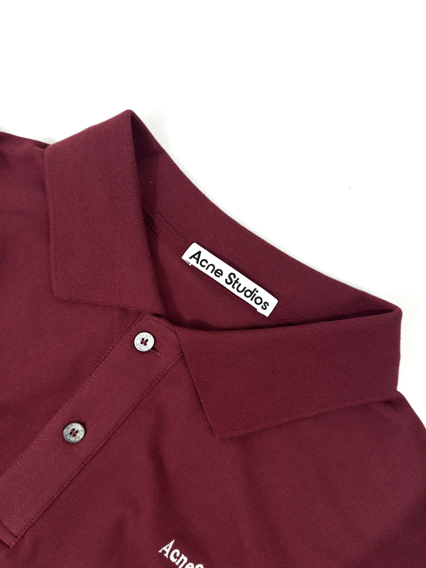 Acne Studios 定制绒壤有机棉 细腻柔软 温润亲肤 岁月沉淀的砖红做旧色 肌理间漫溢克制而隽永的贵气 一枚Acne Studios 徽标 轻落于左胸之上 于低调处镌刻品牌基因 极简却掷地有声 Polo廓形承托日常 徽标细节点亮格调 于简约中 见奢华真意