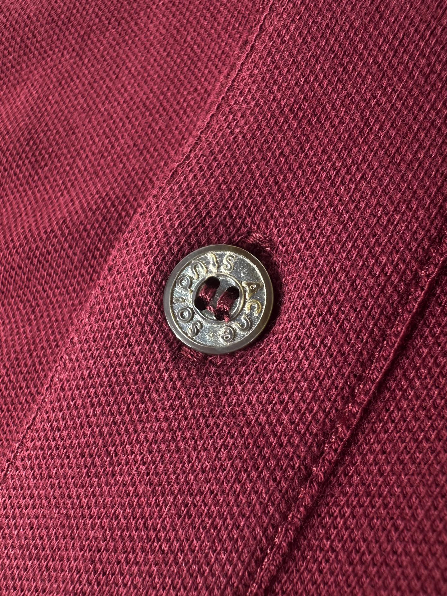 Acne Studios 定制绒壤有机棉 细腻柔软 温润亲肤 岁月沉淀的砖红做旧色 肌理间漫溢克制而隽永的贵气 一枚Acne Studios 徽标 轻落于左胸之上 于低调处镌刻品牌基因 极简却掷地有声 Polo廓形承托日常 徽标细节点亮格调 于简约中 见奢华真意