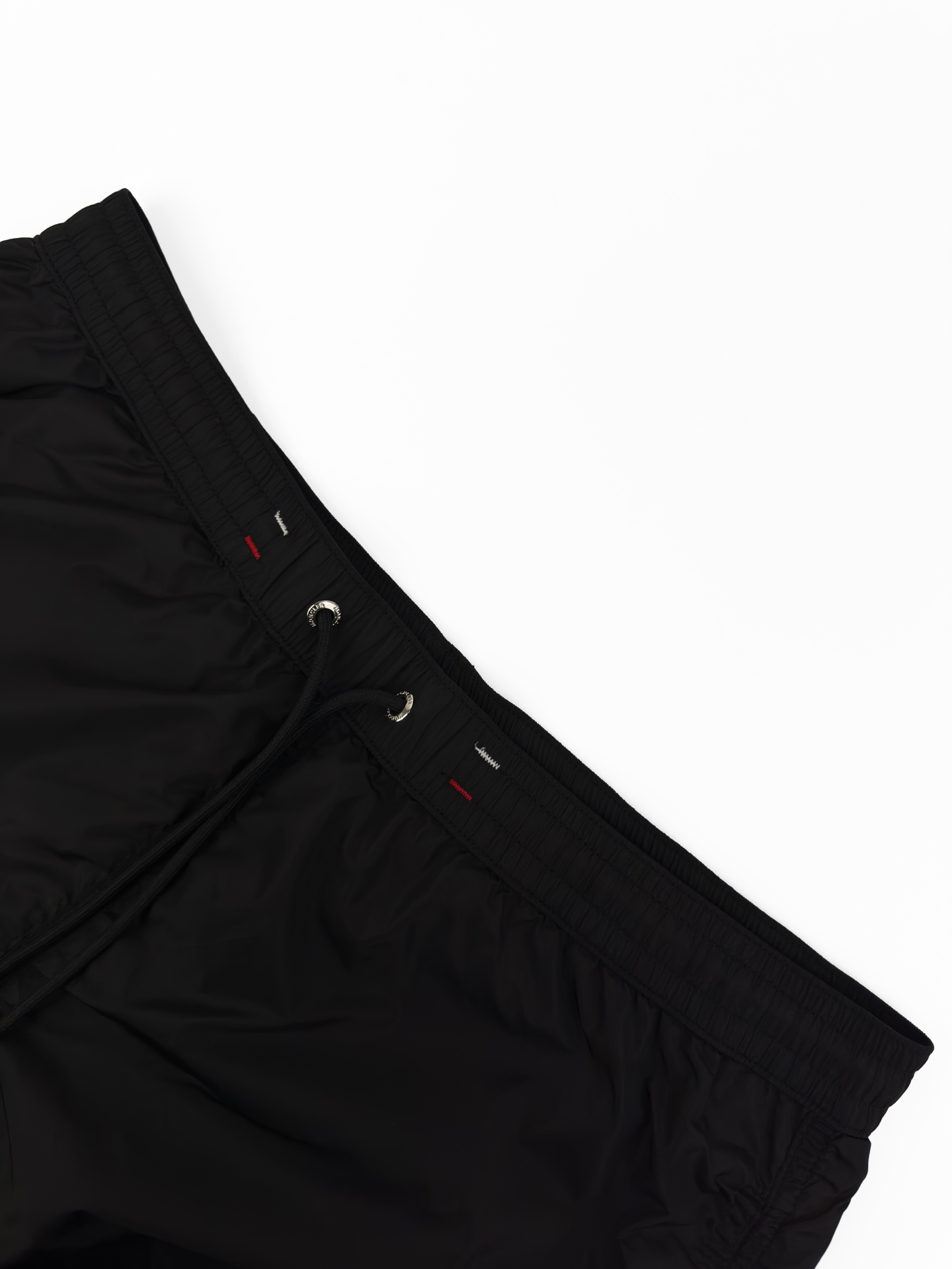 Moncler 定制冰壤棱织尼龙 搭配细密网布衬里 清爽透气 舒适贴肤 以深邃的黑为主色调 纯粹而深邃 标志性Moncler标识贴片轻缀裤身 瞬间为整体造型注入灵魂 彰显品牌魅力 背面巧妙融入拉链口袋 辅以三色饰边点缀 增添层次与动感 每一处细节都是对传统工装的反叛 以轻盈之姿解锁夏日百变奢雅