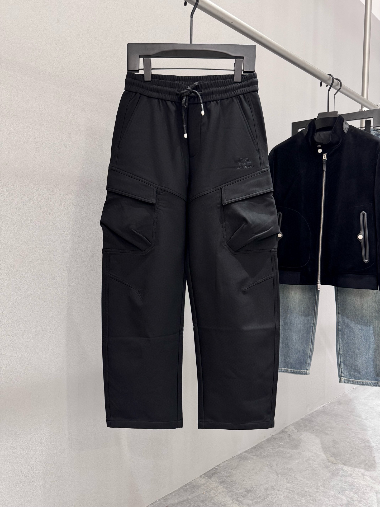 NO:541102,Brand Paris * Family Price Color Black Size M-3XL  Introduction to the new 2025 autumn and winter products of men's multi-pocket wide-leg work pants and produced by OEM. Multi-pocket design is the soul of work pants, both practical and styling. The filament rope decoration on the zipper not only echoes the rough genes of work pants, but also adds soft details with a flowing feeling. The fabric is made of cotton + nylon blended fabric, taking into account the skin-friendly and breathable cotton and the wear-resistant and wrinkle-resistant properties of nylon. Cotton provides a soft touch, and nylon enhances the elasticity of the fabric, which is not easy to deform after wearing it. The surface of the fabric is slightly matte  , low-key and high-end. The mid-waist design and loose trousers form a 'upward and downward' outline, effectively lengthening the leg proportions and covering the defects of the hip and leg, especially suitable for wearers who are pear-shaped figures or seeking comfort. Paired with hooded jackets and dad shoes, the thick-soled design of dad shoes and the work style elements of wide-leg pants in the workwear style of the street fashion attributes, and the Oversize cut of the hooded jacket is the overall relaxed and full of retro atmosphere., versace, jackets  & coats,hats,alexander wang19860909品牌巴黎*世家 价格 颜色黑色 尺码M-3XL 介绍2025秋冬新品男士多口袋阔腿工装裤、代工厂出品.多口袋设计是工装裤的灵魂,兼具实用性与造型感.拉链上的长丝绳装饰,既呼应工装裤的粗犷基因,又以飘逸感增添柔美细节,面料采用棉+锦纶的混纺面料,兼顾棉质的亲肤透气与锦纶的耐磨抗皱特性.棉质提供柔软触感,锦纶增强面料回弹性,久穿不易变形.面料表面略带哑光质感,低调中透露高级感.中腰设计与宽松裤腿形成“上收下放”的轮廓,有效拉长腿部比例,遮盖臀腿瑕疵,尤其适合梨形身材或追求舒适感的穿着者.搭配连帽外套和老爹鞋,老爹鞋的厚底设计与工装阔腿裤的工装风元素自袋街头潮流属性,搭配连帽外套的Oversize裁剪,整体松弛有度,充满复古氛围.,,versace,jackets & coats,hats,alexander wang,Men's clothing