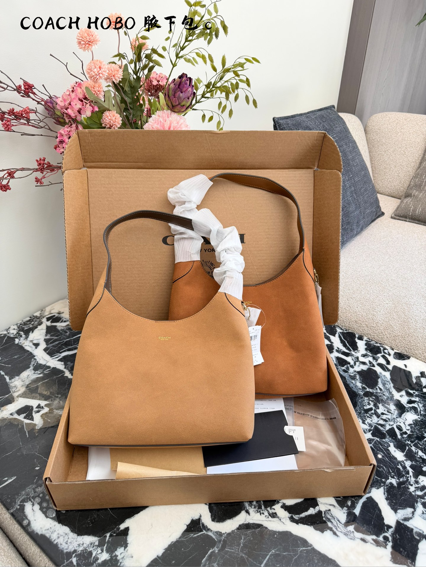 COACH Brooklyn麂皮手袋​​💰280 👜COACH Brooklyn系列手袋，暖棕色麂皮材质，质感柔软细腻，秋冬氛围感满满✨。经典Hobo包型，线条流畅，简约大方，正面C字Logo低调精致。尺寸适中，通勤休闲都很适合，内部空间宽敞，可放13寸笔记本，实用性高👍。麂皮材质需注意防水防污，建议搭配内胆包保护。整体慵懒松弛，秋冬穿搭必备，温暖又高级🍂。28cm小号