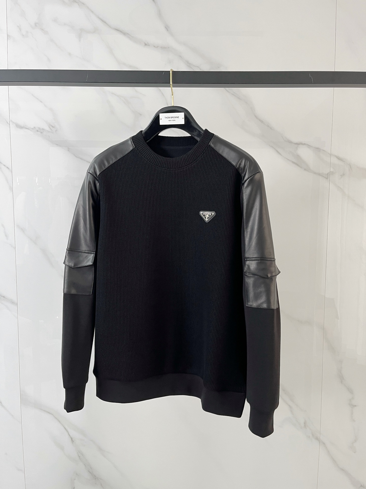 NO:601794,.Prada 2025 Autumn and Winter Wool blended pullover knitted sweatshirt. The geometric patchwork pocket design is very bright. The logo letter buttons highlight the texture. The overall design of the upper body is fashionable and gives a modern atmosphere. The tailoring has a fitted tailoring. The collar slightly fits the neck, making the overall upper body more youthful and fashionable. The fabric is made of custom-woven wool blend material. It has the characteristics of easy care. The surface has the texture of wool. The upper body is comfortable and warm. It looks high-end and has a good crisp feeling at the same time.  Size M-3XL, try on 172-148, wear size L for slim fit, prada, hoodie, sweatshirts, alexander wang19860909.普拉达2025秋冬 羊毛混纺套头针织卫衣 几何拼皮的口袋设计 很有亮点,标志字母纽扣 细节上凸显质感 整体设计上身时尚而赋予现代气息感合体的剪裁,领口微微贴合颈部,让整体上身更显年轻时尚 , 面料采用客供定织羊毛混纺材质 有着易打理的特点 表面有着羊毛质感 上身舒适保暖 ,显高档的同时 又有很好挺括感 码数M-3XL 试穿172-148 穿L码修身感,,prada,hoodie,sweatshirts,alexander wang,Men's clothing