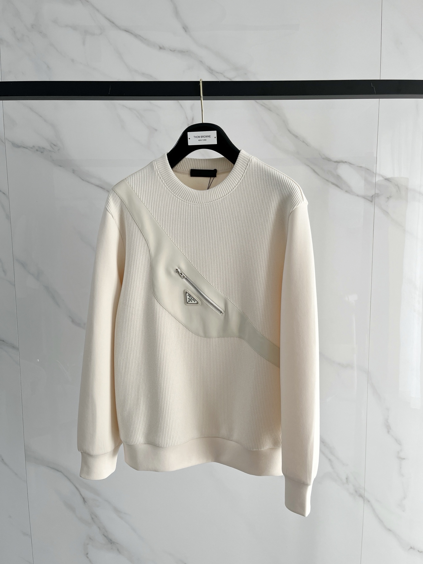 NO:610567,.Prada.2025 Autumn and Winter Wool blended pullover knitted sweatshirt. The geometric patchwork pocket design is very bright. The logo letter buttons highlight the texture. The overall design of the upper body is fashionable and gives a modern atmosphere. The tailoring is fitted, and the collar slightly fits the neck, making the overall upper body more youthful and fashionable. The fabric is made of custom-woven wool blend material. It has the characteristics of easy care. The surface has a wool texture. The upper body is comfortable and warm, and it looks high-end at the same time.  It also has a nice crisp feel. Color: black, beige. Size: M-3XL. Try on 172- Wear size L for slim fit, prada, hoodie, sweatshirts, alexander wang19860909.普拉达.2025秋冬 羊毛混纺套头针织卫衣 几何拼皮的口袋设计 很有亮点,标志字母纽扣 细节上凸显质感 整体设计上身时尚而赋予现代气息感合体的剪裁,领口微微贴合颈部,让整体上身更显年轻时尚 , 面料采用客供定织羊毛混纺材质 有着易打理的特点 表面有着羊毛质感 上身舒适保暖 ,显高档的同时 又有很好挺括感 颜色 黑色 米色 码数M-3XL 试穿172- 穿L码修身感,,prada,hoodie,sweatshirts,alexander wang,Men's clothing