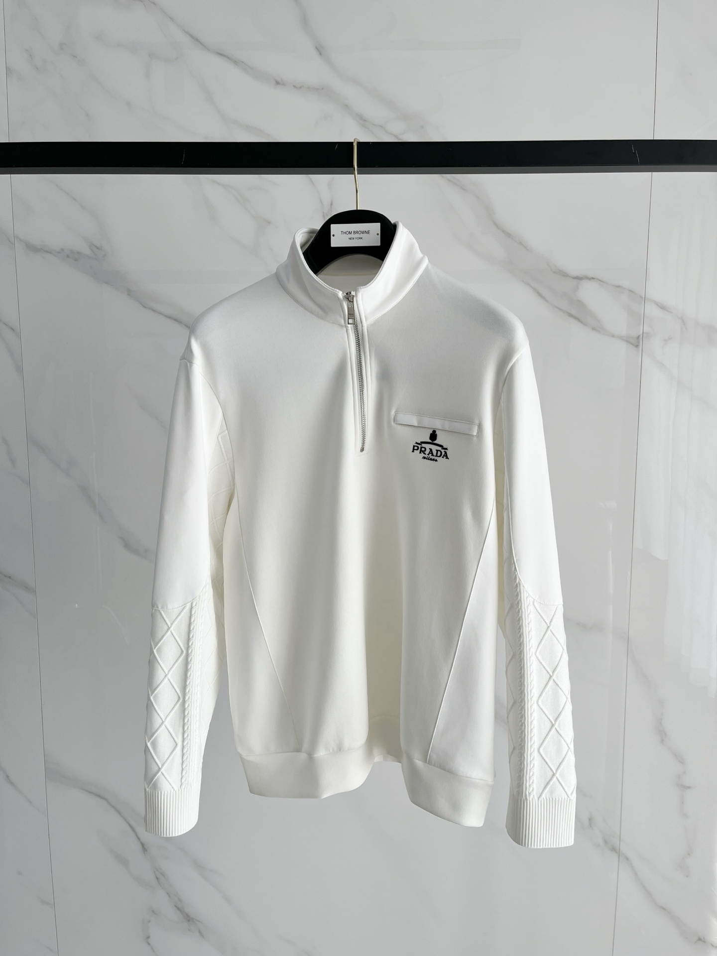 NO:610573,.Prada 2025 Autumn and Winter Wool Blended Pullover Knitted Sweatshirt has a very bright pocket design, and the logo letter buttons highlight the texture. The overall design of the upper body is fashionable and gives a modern feel. The tailoring is fitted, and the collar slightly fits the neck, making the overall upper body look more youthful and fashionable. The fabric is made of custom-woven wool blend material, which is easy to care for. The surface has a wool texture. The upper body is comfortable and warm, and it looks high-end and has a very crisp feel. Color  Black White Size M-3XL Try on 172- Wear size L for a slim fit, prada, hoodie, sweatshirts, alexander wang19860909.普拉达 2025秋冬 羊毛混纺套头针织卫衣 的口袋设计 很有亮点,标志字母纽扣 细节上凸显质感 整体设计上身时尚而赋予现代气息感合体的剪裁,领口微微贴合颈部,让整体上身更显年轻时尚 , 面料采用客供定织羊毛混纺材质 有着易打理的特点 表面有着羊毛质感 上身舒适保暖 ,显高档的同时 又有很好挺括感 颜色 黑色 白色码数M-3XL 试穿172- 穿L码修身感,,prada,hoodie,sweatshirts,alexander wang,Men's clothing