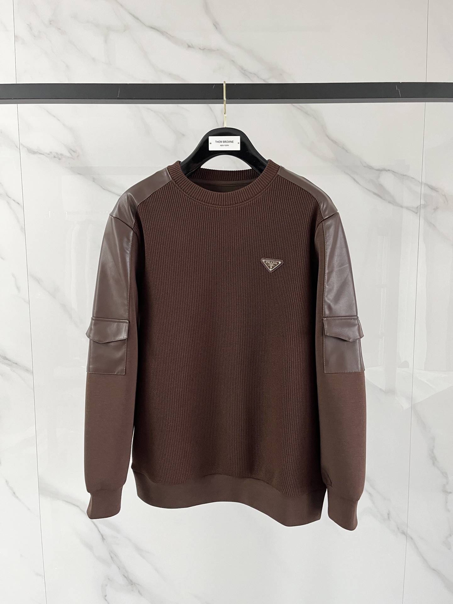 NO:601769,.Prada 2025 Autumn and Winter Wool blended pullover knitted sweatshirt. The geometric patchwork pocket design is very bright, and the logo letter buttons highlight the texture. The overall design of the upper body is fashionable and gives a modern atmosphere. The tailoring is fitted, and the collar slightly fits the neck, making the overall upper body more youthful and fashionable. The fabric is made of custom-woven wool blend material. It has the characteristics of easy care. The surface has a wool texture. The upper body is comfortable and warm, and it looks high-end at the same time.  It also has a nice stiff feel. Color: black, brown, gray. Size: M-3XL. Try on 172-148. Wear size L for a slim fit. Prada, hoodie, sweatshirts, alexander wang19860909.普拉达 2025秋冬 羊毛混纺套头针织卫衣 几何拼皮的口袋设计 很有亮点,标志字母纽扣 细节上凸显质感 整体设计上身时尚而赋予现代气息感合体的剪裁,领口微微贴合颈部,让整体上身更显年轻时尚 , 面料采用客供定织羊毛混纺材质 有着易打理的特点 表面有着羊毛质感 上身舒适保暖 ,显高档的同时 又有很好挺括感 颜色 黑色 咖色 灰色 码数M-3XL 试穿172-148 穿L码修身感,,prada,hoodie,sweatshirts,alexander wang,Men's clothing