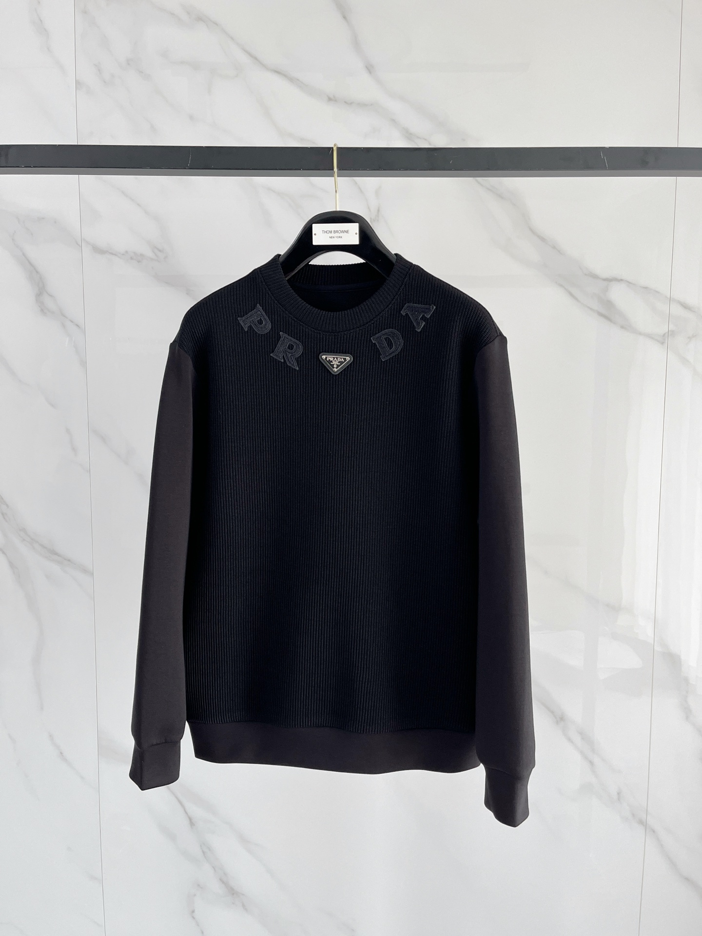 NO:601778,.Prada 2025 Autumn and Winter Wool blended pullover knitted sweatshirt. The geometric patchwork pocket design is very bright, and the logo letter buttons highlight the texture. The overall design of the upper body is fashionable and gives a modern atmosphere. The tailoring is fitted, and the collar slightly fits the neck, making the overall upper body more youthful and fashionable. The fabric is made of custom-woven wool blend material. It has the characteristics of easy care. The surface has a wool texture. The upper body is comfortable and warm, and it looks high-end at the same time.  It also has a nice crisp feel. Color: black, beige. Size: M-3XL. Try on 172-148. Wear size L for a slim fit. Prada, hoodie, sweatshirts, alexander wang19860909.普拉达 2025秋冬 羊毛混纺套头针织卫衣 几何拼皮的口袋设计 很有亮点,标志字母纽扣 细节上凸显质感 整体设计上身时尚而赋予现代气息感合体的剪裁,领口微微贴合颈部,让整体上身更显年轻时尚 , 面料采用客供定织羊毛混纺材质 有着易打理的特点 表面有着羊毛质感 上身舒适保暖 ,显高档的同时 又有很好挺括感 颜色 黑色 米色 码数M-3XL 试穿172-148 穿L码修身感,,prada,hoodie,sweatshirts,alexander wang,Men's clothing