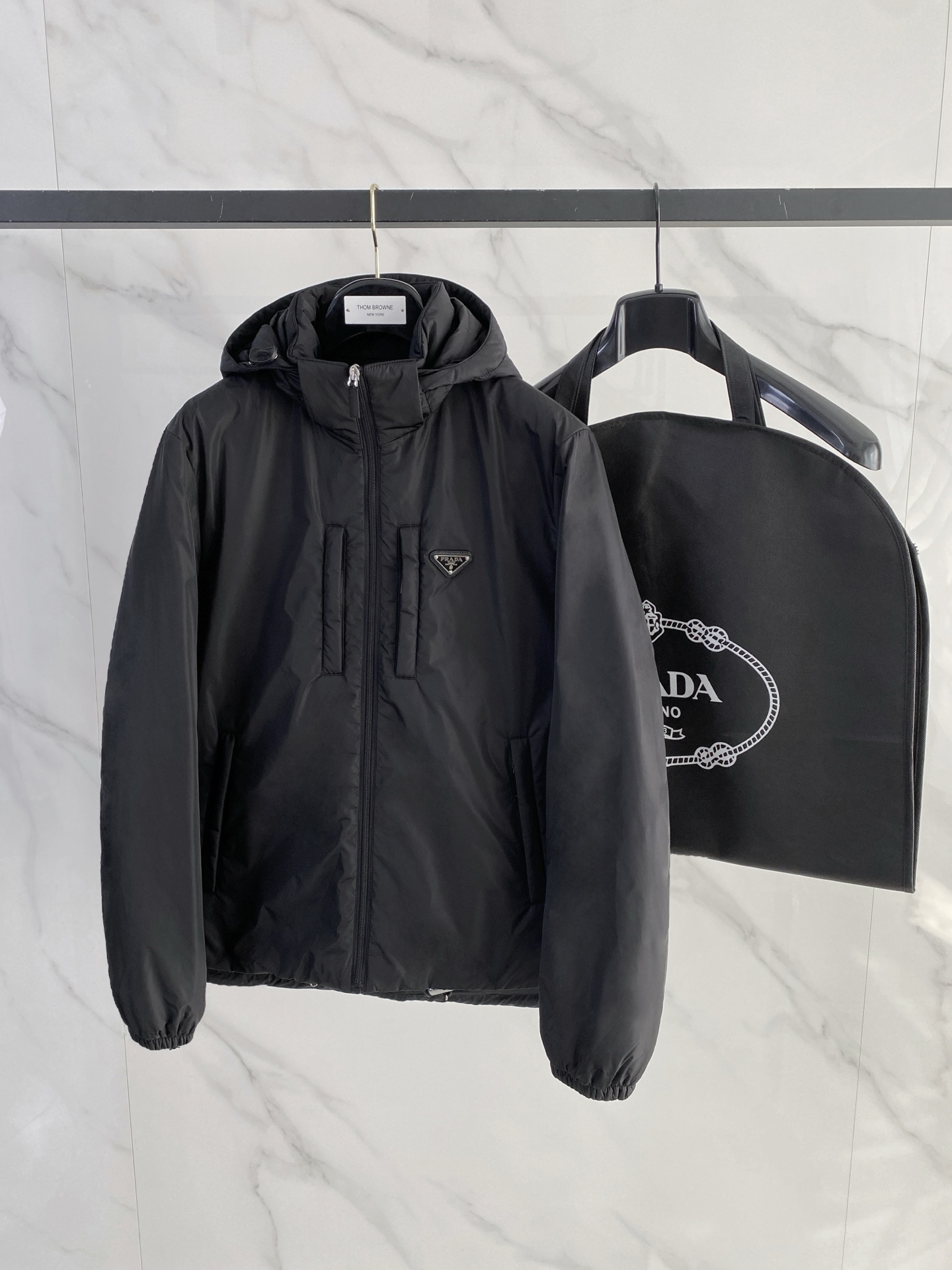 NO:684833,Special down Prada Re-Nylon limited edition down jacket. Filled with goose down inside. Comes with original hardware kit. Channel premium product. Comes standard with hanger/original nylon suit storage bag/shopping bag/airplane box. Complete gift box, hanging at home. Product details  This recycled nylon down jacket is decorated with exquisite details such as a triangular metal logo, and combines technical design and sportswear elements to make it distinctive. The jacket is equipped with front pockets and a drawstring hood, which is lined with soft goose down for warmth and comfort. To ensure the sustainable care of the product, maintain its properties and reduce its impact on the environment, it is recommended not to wash the product frequently, let it dry naturally after each use, and entrust it to a professional environmentally friendly dry cleaner for dry cleaning. Product details Stand-up collar Removable hood with elastic rubber drawstring  Exposed center front zip with zip puller Chest welt pocket with enameled metal triangle logo Angled welt pocket with zipper Lined Elastic cuffs Elastic drawcord at hem with metal stoppers Enamel triangle logo Rounded hem Polyamide fabric Size: 48-56 black/navy,,prada,jackets & coats,jackets & coats,down jacket,business suit,hats,19860909特级羽绒Prada Re-Nylon限定款羽绒夹克.内里填充鹅绒.搭配原厂五金套件.渠道臻品. 标配衣架/原版尼龙西装收纳袋/购物袋/飞机盒.全套礼盒,挂装到家 产品详情 这款再生尼龙羽绒外套饰有三角形金属徽标等精美细节,并融科技设计和运动着装元素于一身,特色鲜明.外套配有正面口袋和束绳兜帽,以柔软的鹅绒加衬,温暖舒适. 为确保产品的可持续护理,保持其特性并减少其对环境的影响,建议不要频繁清洗产品,每次使用后让其自然晾干,并委托专业的环保干洗店进行干洗. 产品详情 立领 可拆卸兜帽,配弹力橡胶束绳 正面中心外露式拉链,配拉链拉头 胸前嵌线袋,配涂珐琅三角形金属徽标 斜角嵌线袋,配拉链 有衬里 弹力袖口 下摆弹力束绳,配金属止扣 三角形珐琅徽标 圆形下摆 聚酰胺纤维面料 Size : 48-56 黑色/藏青,,prada,jackets & coats,jackets & coats,down jacket,business suit,hats,,Men's clothing