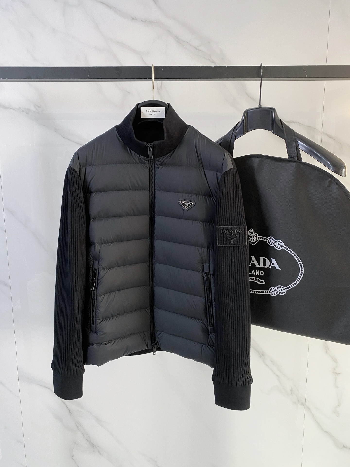 NO:657543,Prada*'s new men's classic plaid down knitted jacket has a simple and elegant overall style. It uses black knitted stitching to present a neat temperament on the outside, and the iconic classic plaid is embellished on the inside to form a sharp contrast. The jacket is filled with 90 white goose down. It is guaranteed to be light and fluffy while having good thermal insulation properties.  The inner plaid arrangement is symmetrical, with rigorous details. The fabric is smooth and wrinkle-resistant, with a delicate touch. It is crisp and stylish to wear and is not prone to creases, which improves the practicality of daily use. The body is fully padded and has excellent fluffiness, ensuring that it still maintains a comfortable and warm feeling in cold weather. The overall design takes into account both practicality and beauty, while retaining the Burberry  Iconic British style, and through modern technology, it presents a high-end texture that is both fashionable and comfortable.,,burberry,prada,jackets & coats,down jacket,alexander wang19860909普拉达* 新款男装 经典格纹羽绒针织夹克 整体款式简洁大方,以黑色针织拼接外观呈现利落气质,内里则点缀标志性的经典格纹,形成鲜明对比.夹克 90白鹅绒填充. 保证轻盈蓬松的同时具备良好的保暖性能. 内里格纹排布对称,细节严谨,面料顺滑且抗皱,触感细腻,穿着挺括有型,不易产生折痕,提升了日常使用的实穿性.衣身填充饱满,蓬松度出色,确保在寒冷天气中依旧保持舒适的保暖感受. 整体设计兼顾实用与美观,既保留 巴宝莉 标志性的英伦格调,又通过现代工艺呈现出时尚与舒适兼备的高端质感.,,burberry,prada,jackets & coats,down jacket,alexander wang,Men's clothing