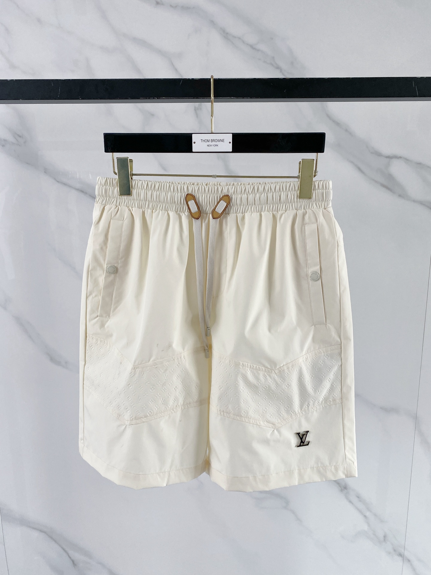 NO:848795,LV  2026ss summer limited functional casual shorts, which perfectly combine the brand's iconic Monogram dark pattern with modern tailoring. Made of high-density nylon fabric, which has both drape and breathability, and is not afraid of the sweltering summer heat; the waistband is designed with elastic drawstrings and contrasting color rope buckle points  The details are exquisite. The three-dimensional laminated pockets on the front and customized hardware buckles are both practical and recognizable. The metal LV logo on the trouser legs is a low-key statement. The neat straight silhouette is suitable for various scenes. Whether it is for vacation or daily wear, it can easily create a relaxed and high-quality style.  Color Black Beige Size 48-56, Louis Vuitton, shorts,19860909LV 2026ss夏季限定机能风休闲短裤,将品牌标志性Monogram暗纹与现代剪裁完美融合.甄选高密锦纶面料打造,兼具垂坠感与透气性,无惧夏日闷热；腰头采用松紧抽绳设计,搭配撞色绳扣点缀,细节尽显精致.前侧立体压胶口袋与定制五金扣兼具实用与辨识度,裤脚处的金属LV标识低调点题,利落直筒版型适配多元场景,无论是度假出行还是日常穿搭,都能轻松塑造松弛高级的质感格调. 颜色黑色 米色 码数48-56,,louis vuitton,shorts,,Men's clothing