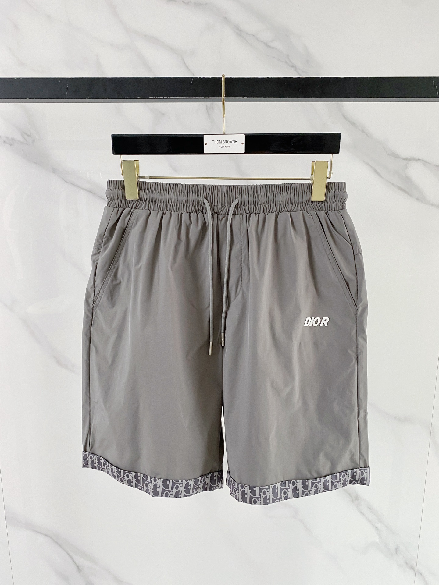 NO:848799,Dior Dior  The 2026ss summer limited edition Oblique presbyopic patchwork casual shorts cleverly combine the brand's iconic elements with modern functional tailoring. Made of high-density anti-wrinkle nylon fabric, the upper body is light and breathable, with a drapey texture, and is not afraid of the sweltering summer heat. The waistband is designed with elastic drawstrings and metal rope head details for comfort.  Comfortable and sophisticated; the iconic Oblique cuffing design on the legs of the trousers is a low-key way to inject brand recognition. It is matched with the eye-catching Dior letter logo on the front and the CD badge pocket on the back, and is full of details. The loose straight version modifies the leg shape, and can easily create a relaxed and high-quality style whether it is for vacation or daily wear.  Color Black Gray Size 48-56,,dior,dior,shorts,19860909Dior 迪奥 2026ss夏季限定Oblique老花拼接休闲短裤,将品牌标志性元素与现代机能剪裁巧妙融合.甄选高密抗皱尼龙面料打造,上身轻薄透气,自带垂坠质感,无惧夏日闷热.腰头采用松紧抽绳设计,搭配金属绳头细节,兼顾舒适与精致；裤脚标志性Oblique老花翻边设计,低调注入品牌辨识度,搭配正面醒目Dior字母标识与背面CD徽章口袋,细节拉满.宽松直筒版型修饰腿型,无论是度假出行还是日常穿搭,都能轻松塑造松弛高级的质感格调. 颜色黑色 灰色 码数48-56,,dior,dior,shorts,,Men's clothing