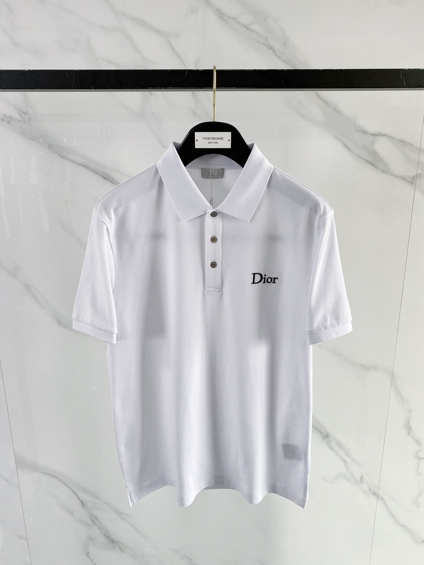 NO:848792,Dior Dior 2026 Spring and Summer New Style | Dior Classic Logo Polo Shirt is made of high-density piqué cotton fabric, breathable and dry, perfect for the hot weather in spring and summer. The neat lapels are matched with a three-button placket, the fit is crisp but not soft; the exquisite brand embroidery on the chest low-key releases the brand texture. The black and white two-color classic and versatile, whether it is commuting or daily leisure, you can easily create a simple and high-end urban outfit. It is a must-have spring and summer wardrobe item. Color black  White code number 48-56,,dior,dior,19860909Dior 迪奥 2026 春夏新款 | Dior 经典标识Polo衫 甄选高密珠地棉面料,透气干爽,完美适配春夏高温天气.利落翻领搭配三粒扣门襟,版型挺括不软塌；胸口精致品牌刺绣,低调释放品牌质感.黑白双色经典百搭,无论是通勤还是日常休闲,都能轻松打造简约高级的都市穿搭,是衣橱必备的春夏刚需款. 颜色黑色 白色 码数48-56,,dior,dior,,Men's clothing