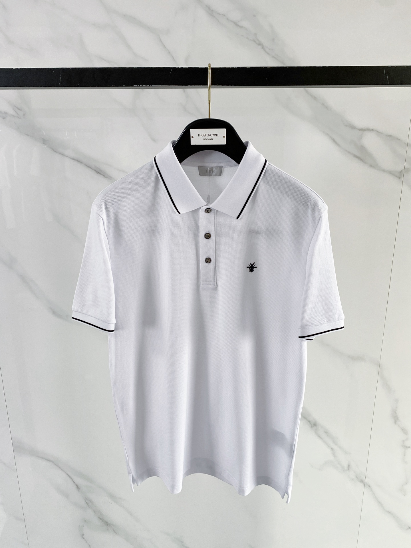 NO:848794,Dior Dior 2026ss spring and summer new style | Dior bee embroidered Polo shirt  The high-density breathable piqué cotton fabric is selected, with a delicate touch, and the upper body is dry and not sweaty, which is perfect for the hot weather in spring and summer. The contrasting edge collar and cuff design are neat and stylish; the delicate bee embroidery on the chest low-key highlights the brand recognition. The black and white two-color classic and versatile, whether it is commuting business or daily leisure, you can easily create a simple and high-end urban outfit, which is a must-have for the spring and summer wardrobe. Color black white  Code number 48-56,,dior,dior,19860909Dior 迪奥 2026ss春夏新款 | Dior 蜜蜂刺绣Polo衫 甄选高密透气珠地棉面料,触感细腻,上身干爽不闷汗,完美适配春夏高温天气.撞色包边领+袖口设计,利落有型；胸口精致小蜜蜂刺绣,低调彰显品牌辨识度.黑白双色经典百搭,无论是通勤商务还是日常休闲,都能轻松打造简约高级的都市穿搭,是春夏衣橱的刚需款. 颜色黑色 白色 码数48-56,,dior,dior,,Men's clothing