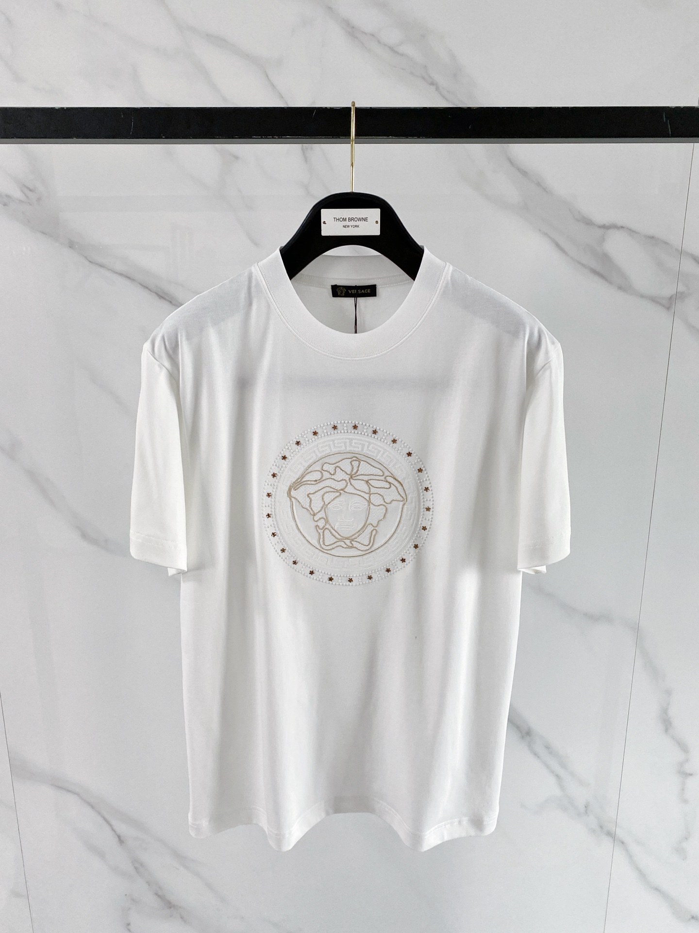 NO:848788,Versace 2026 spring and summer new style Versace Medusa embroidered short-sleeved T-shirt, the brand's iconic Medusa head embroidery is matched with a Greek key border, which has a kingly aura. The high-count cotton fabric is draped and crisp, and the three-dimensional embroidery technology is exquisite and full, showing the brand recognition in a low-key manner. The slightly loose shoulder cut is modified to modify the shoulder line, and the black/white two-tone color is suitable for all spring and summer outfits, and it is easy to achieve advanced casual style.  Size S-XXL,,versace,versace,T-shirt,tees,t-shirt,19860909范思哲 2026春夏新款 Versace美杜莎刺绣短袖T恤,品牌标志性美杜莎头像刺绣搭配希腊回纹边框,自带王者气场 高支棉面料垂坠挺括,立体刺绣工艺精致饱满,低调中尽显品牌辨识度 微宽松落肩剪裁修饰肩线,黑/白双色适配所有春夏穿搭,轻松拿捏高级休闲风 码数S-XXL,,versace,versace,T-shirt,tees，t-shirt,,Men's clothing