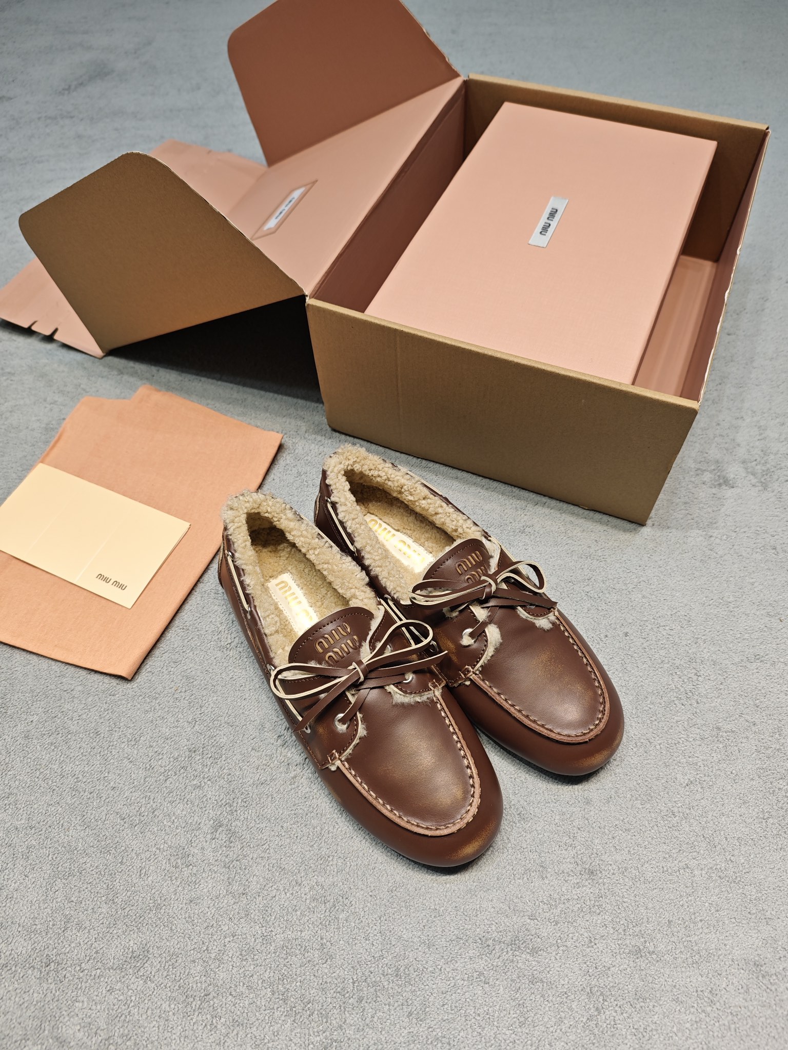 NO:693249,Miu Mi* 26ss retro wool warm lace-up flat loafers, classic boat shoe shape + distressed brown leather, with the brand's iconic 'Miu Miu embossing + lace bow', a combination of sweet elements and retro texture, highly recognizable; the interior is lined with thick lamb wool, which combines winter warmth with a soft and waxy feel.  Versatile style for autumn and winter - pairing with woolen pants is a 'college girl style', matching with a short skirt and pile of socks is 'sweet and cool girly', and can even be worn with a coat for a casual route. It is a winter shoe that is 'warm without losing a sense of fashion'. The shoe shape is loose and does not squeeze the feet, and the rubber sole is light and non-slip, which can not only cope with daily commuting, but also meet the needs of warmth in low temperature environments. The upper layer is cowhide, the lining is wool, and the original rubber outsole is increased by 2cm.  size 35-40 (customized size 40 is non-refundable). Need airplane box + 6, loafers, fur shoes, miumiu, loafers, skirts, cowhide19860909Miu Mi* 26ss复古羊毛保暖系带平底乐福鞋 经典船鞋型+做旧棕皮革,搭配品牌标志性的“Miu Miu压纹+系带蝴蝶结”,甜美元素和复古质感结合,辨识度很高；内里是厚实羊羔毛衬里,兼顾了冬日保暖和软糯脚感. 秋冬万能款——搭毛呢裤是“学院大小姐风”,配短裙+堆堆袜是“甜酷少女感”,甚至能搭大衣走轻熟路线,属于“保暖又不丢时髦感”的冬日鞋款.鞋型宽松不挤脚,橡胶鞋底轻便防滑,既能应对日常通勤,又能满足低温环境下的保暖需求. 鞋面头层牛皮 内里羊毛 大底原版橡胶大底 增高2cm size35-40码（40码定制不退换） 要飞机盒+6,乐福鞋毛毛鞋,miumiu,loafers,skirts,cowhide,Women's Shoes