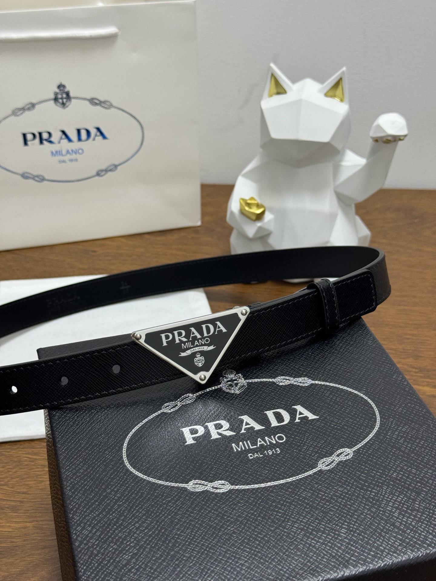 PRADA 2.5cm 颜色：黑色十字纹皮革腰带风格简约之作醒目装饰涂珐琅三角形金属徽标柔软自然，赋予设