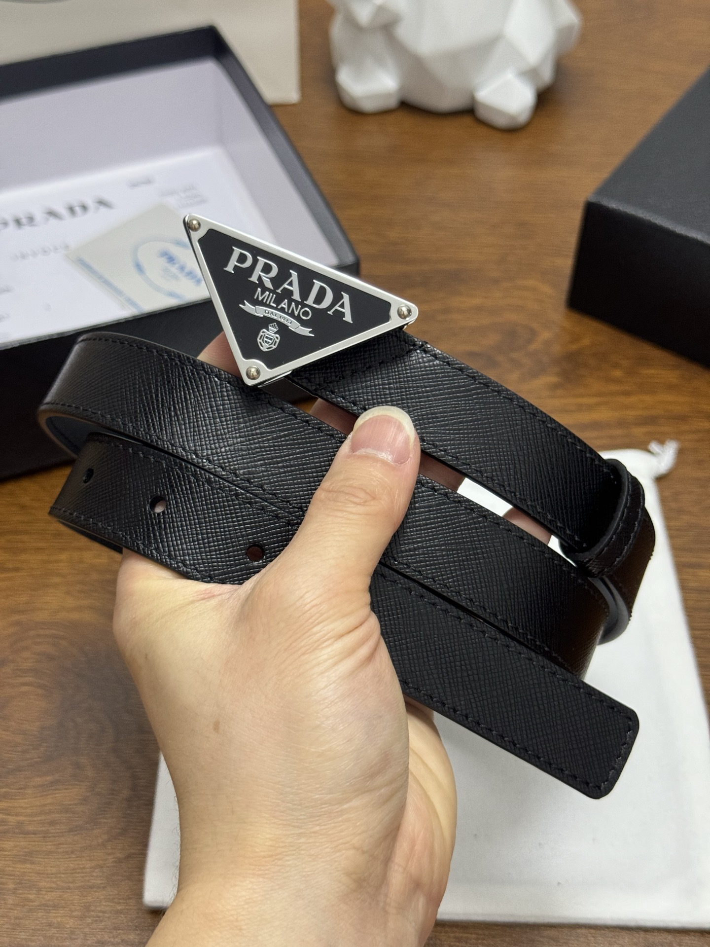 PRADA 2.5cm 颜色：黑色十字纹皮革腰带风格简约之作醒目装饰涂珐琅三角形金属徽标柔软自然，赋予设