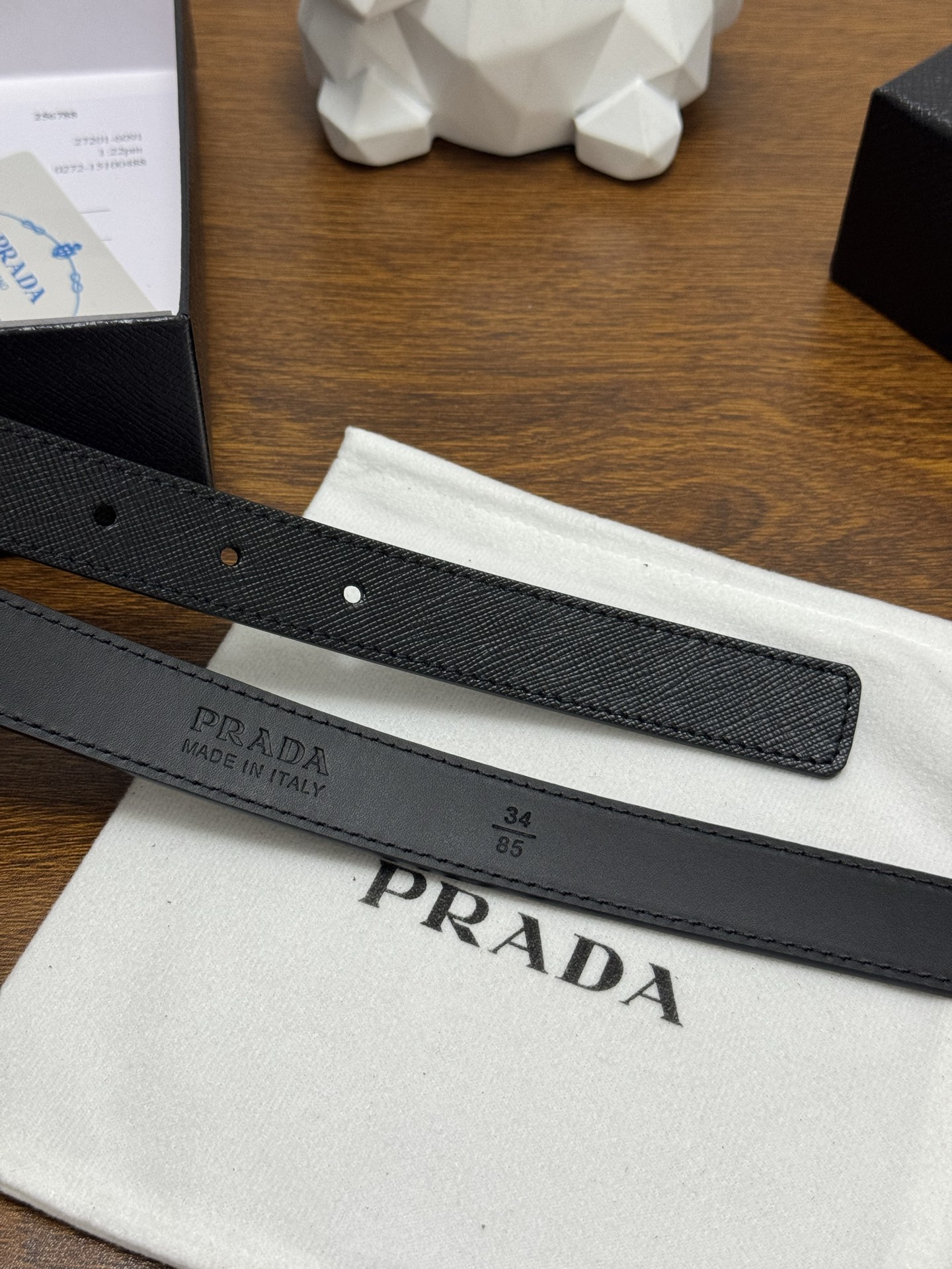 PRADA 2.5cm 颜色：黑色十字纹皮革腰带风格简约之作醒目装饰涂珐琅三角形金属徽标柔软自然，赋予设