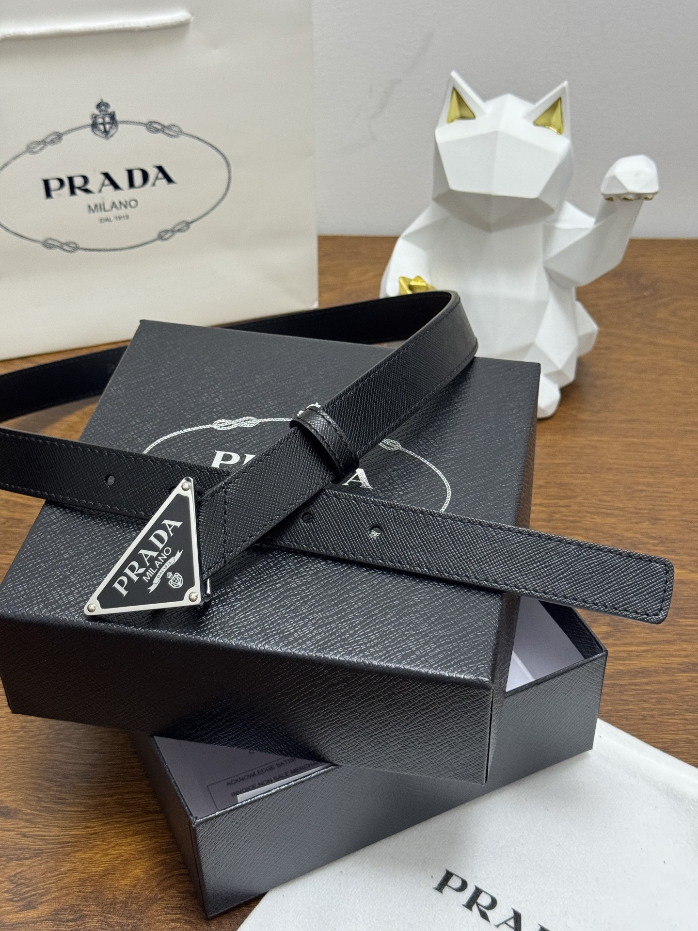 PRADA 2.5cm 颜色：黑色十字纹皮革腰带风格简约之作醒目装饰涂珐琅三角形金属徽标柔软自然，赋予设