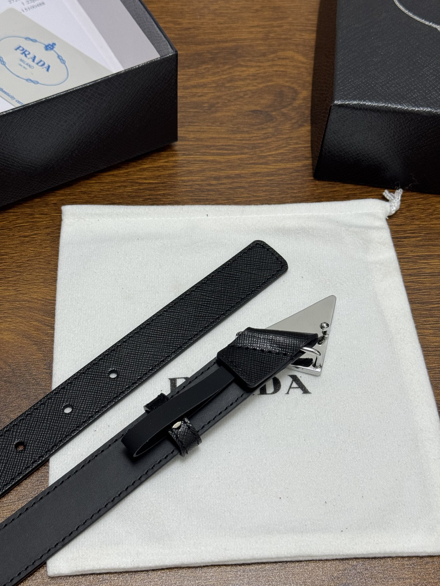 PRADA 2.5cm 颜色：黑色十字纹皮革腰带风格简约之作醒目装饰涂珐琅三角形金属徽标柔软自然，赋予设