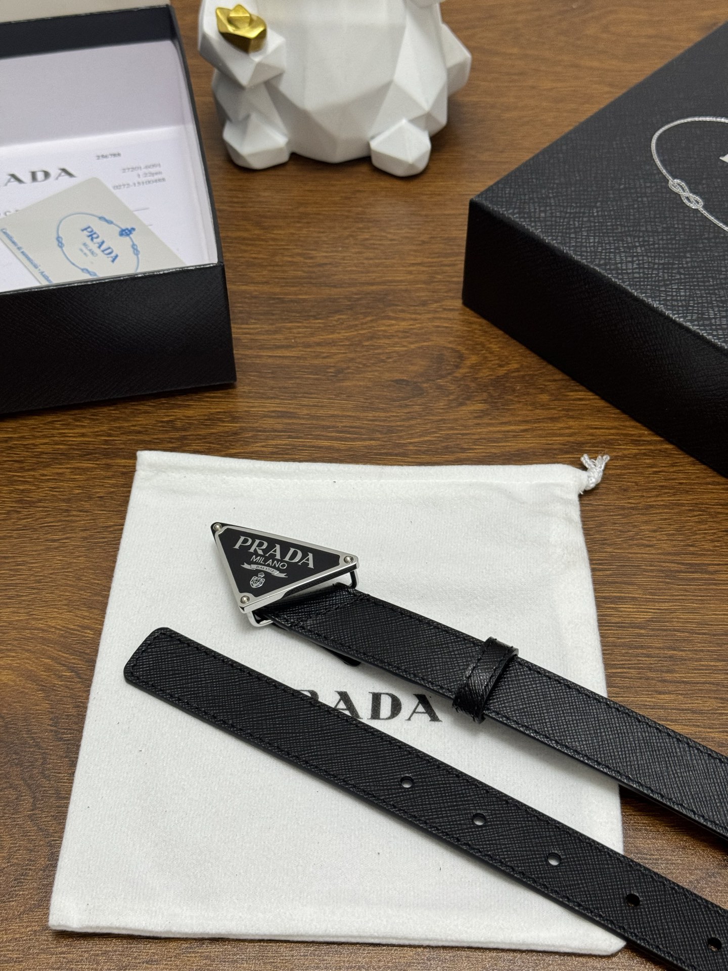 PRADA 2.5cm 颜色：黑色十字纹皮革腰带风格简约之作醒目装饰涂珐琅三角形金属徽标柔软自然，赋予设