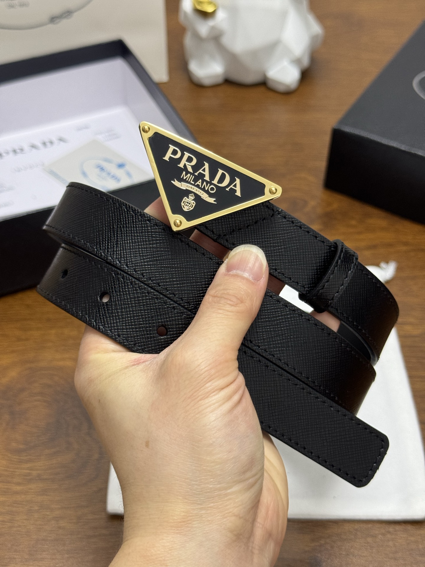 PRADA 2.5cm 颜色：黑色十字纹皮革腰带风格简约之作醒目装饰涂珐琅三角形金属徽标柔软自然，赋予设