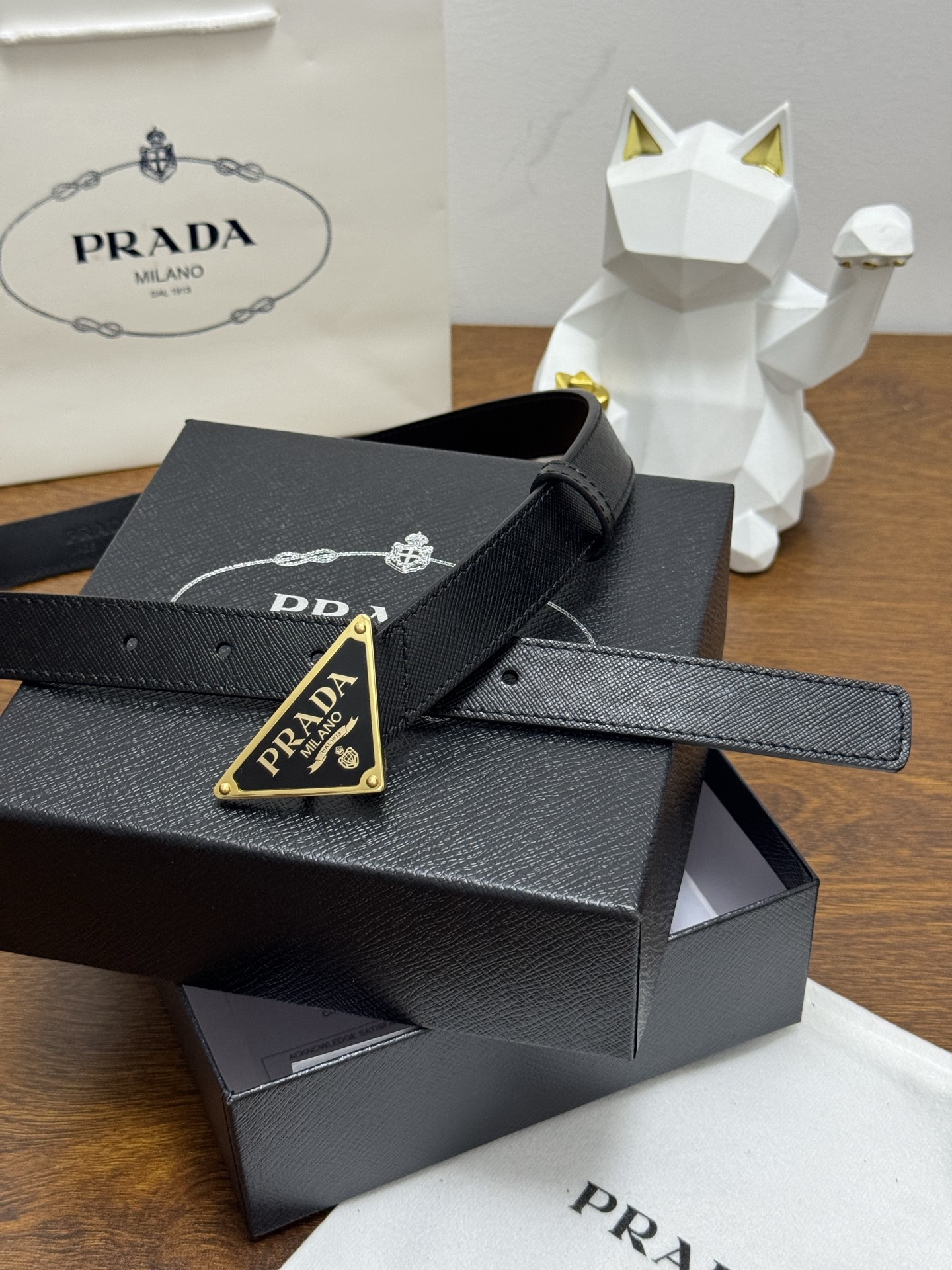 PRADA 2.5cm 颜色：黑色十字纹皮革腰带风格简约之作醒目装饰涂珐琅三角形金属徽标柔软自然，赋予设