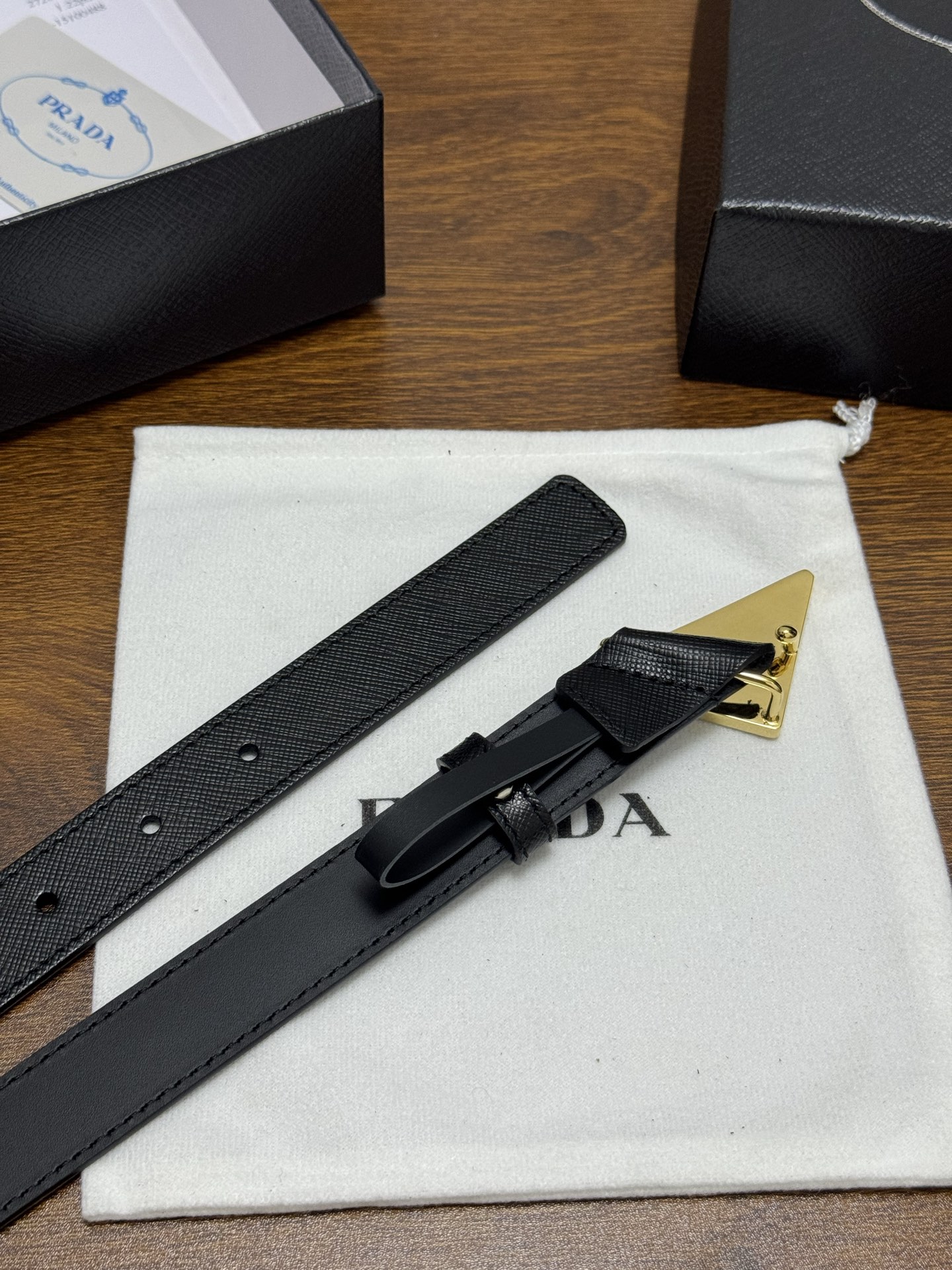 PRADA 2.5cm 颜色：黑色十字纹皮革腰带风格简约之作醒目装饰涂珐琅三角形金属徽标柔软自然，赋予设