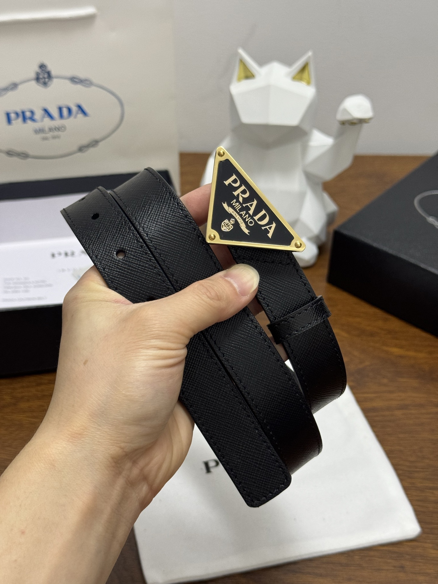 PRADA 2.5cm 颜色：黑色十字纹皮革腰带风格简约之作醒目装饰涂珐琅三角形金属徽标柔软自然，赋予设