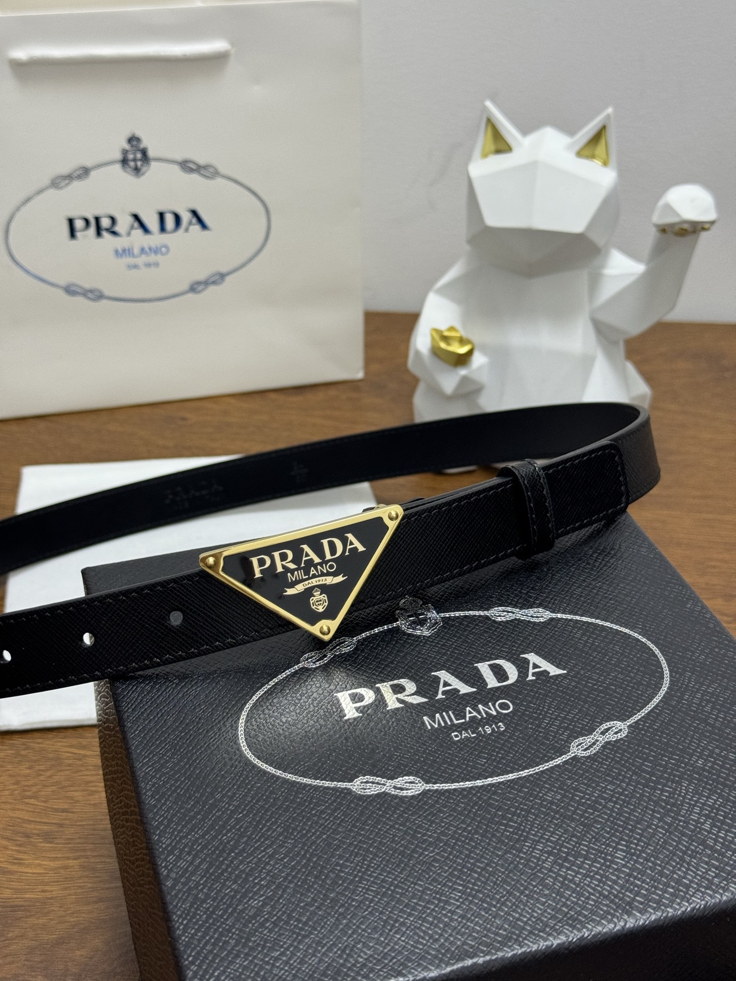PRADA 2.5cm 颜色：黑色十字纹皮革腰带风格简约之作醒目装饰涂珐琅三角形金属徽标柔软自然，赋予设