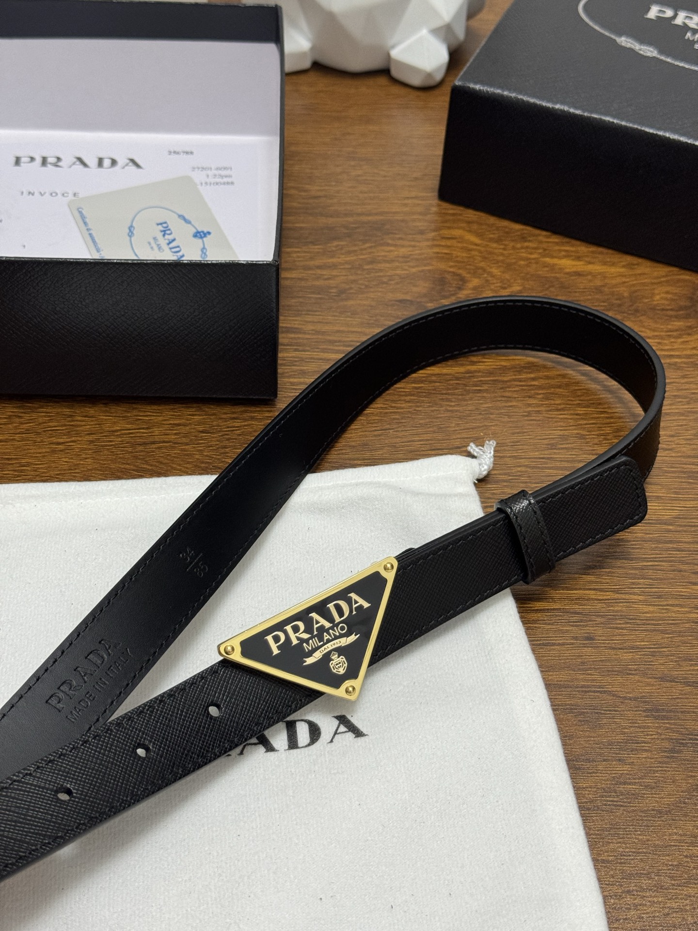 PRADA 2.5cm 颜色：黑色十字纹皮革腰带风格简约之作醒目装饰涂珐琅三角形金属徽标柔软自然，赋予设