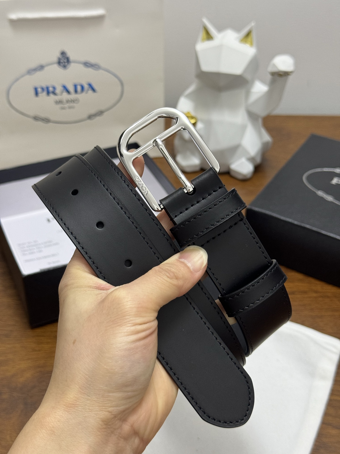 PRADA 3.5cm 颜色：黑色平面纹皮革腰带风格简约之作醒目装饰涂珐琅金属徽标柔软自然，赋予设计百搭