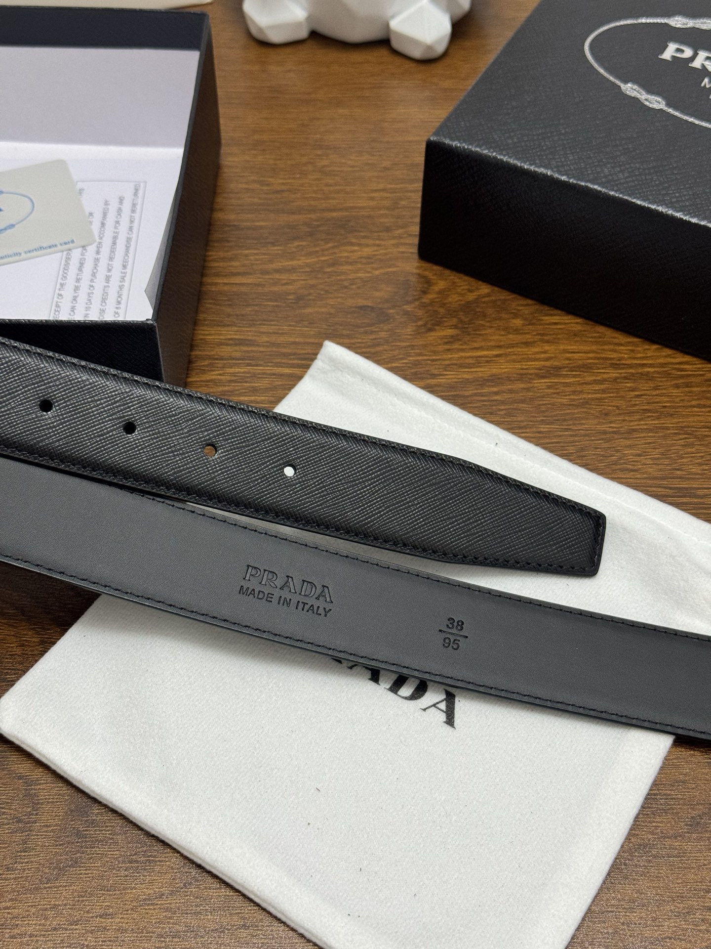 PRADA 3.5cm 颜色：黑色十字纹皮革腰带风格简约之作醒目装饰涂珐琅三角形金属徽标柔软自然，赋予设