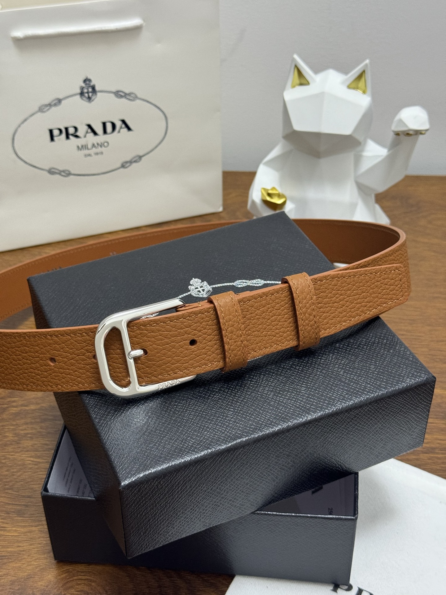 PRADA 3.5cm 颜色：棕色荔枝纹皮革腰带风格简约之作醒目装饰涂珐琅三角形金属徽标柔软自然，赋予设