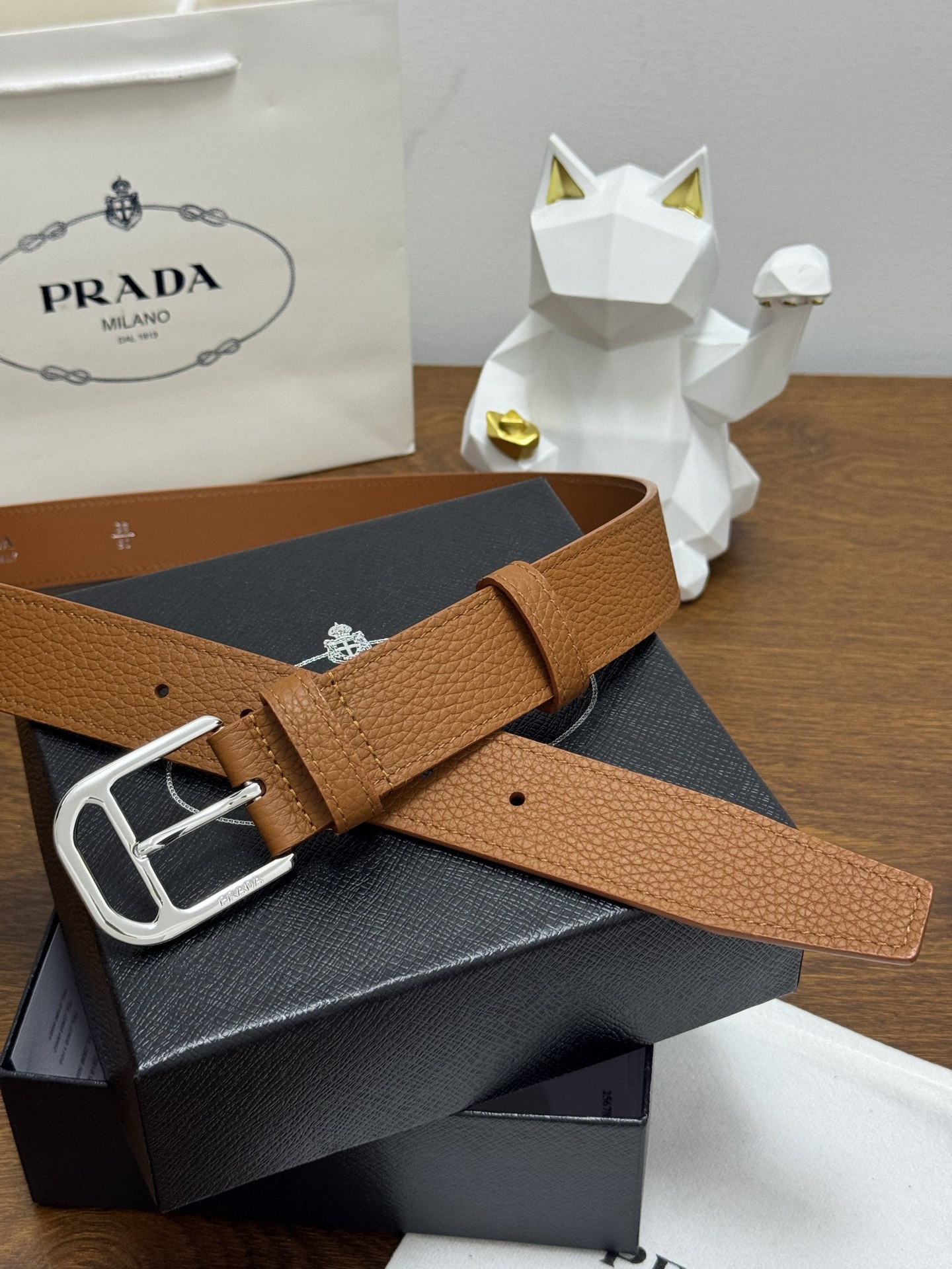 PRADA 3.5cm 颜色：棕色荔枝纹皮革腰带风格简约之作醒目装饰涂珐琅三角形金属徽标柔软自然，赋予设