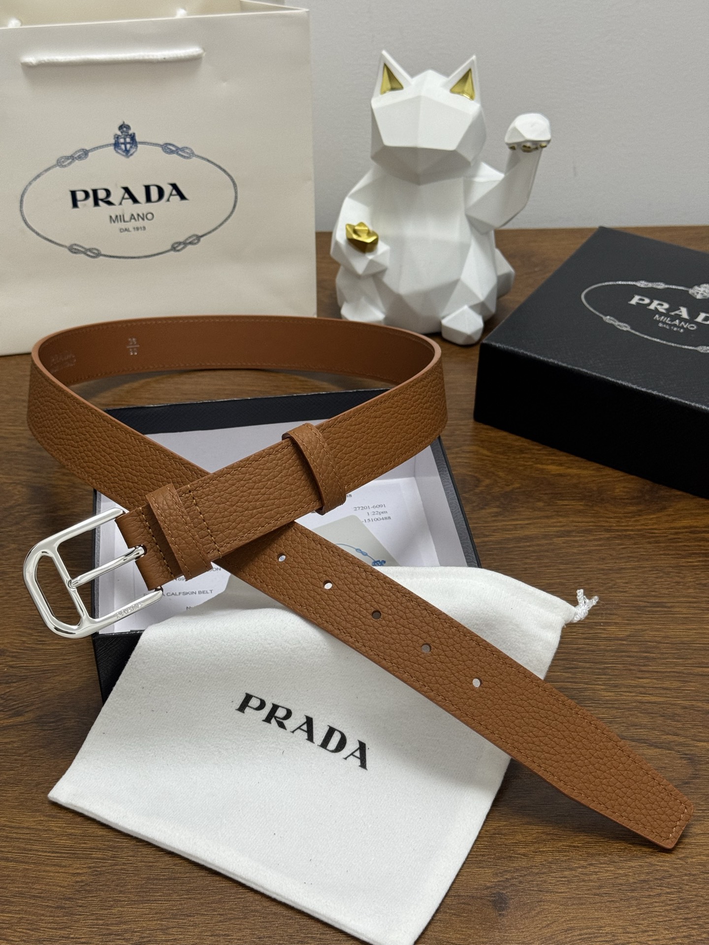 PRADA 3.5cm 颜色：棕色荔枝纹皮革腰带风格简约之作醒目装饰涂珐琅三角形金属徽标柔软自然，赋予设
