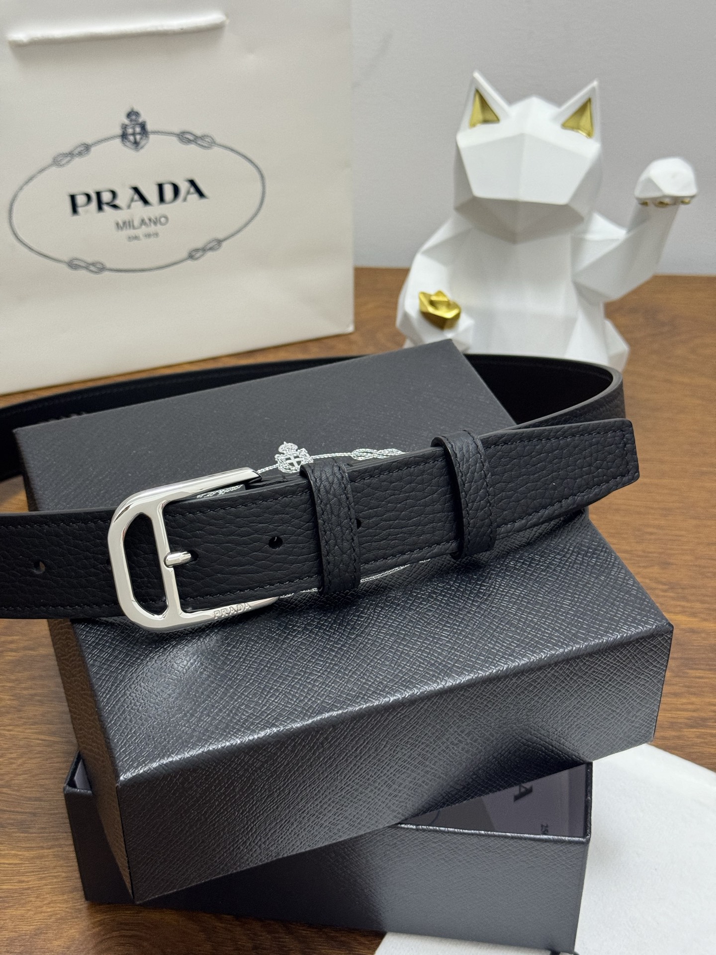 PRADA 3.5cm 颜色：黑色荔枝纹皮革腰带风格简约之作醒目装饰涂珐琅三角形金属徽标柔软自然，赋予设