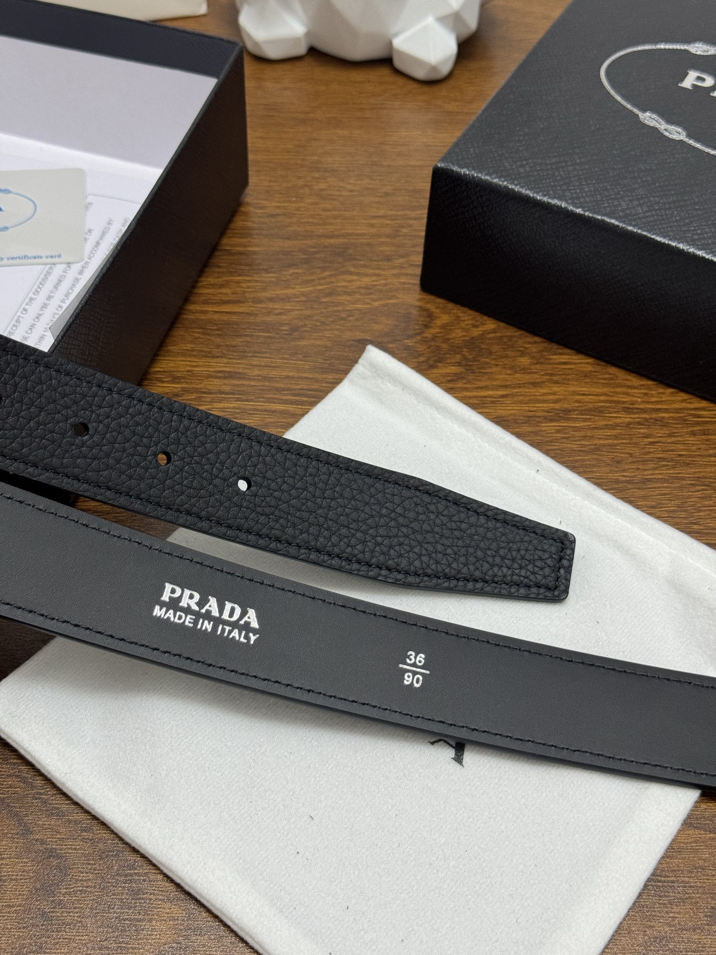 PRADA 3.5cm 颜色：黑色荔枝纹皮革腰带风格简约之作醒目装饰涂珐琅三角形金属徽标柔软自然，赋予设