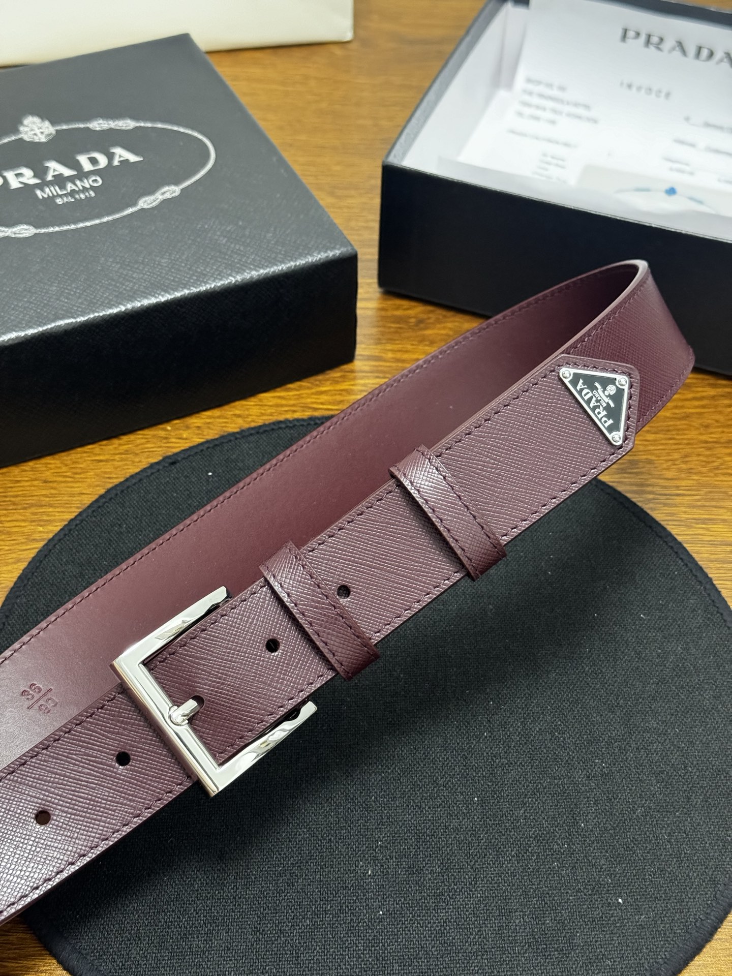 PRADA   3.5cm     枣红Saffiano牛皮革腰带设计简约精致，饰有标志性的涂珐琅三角形