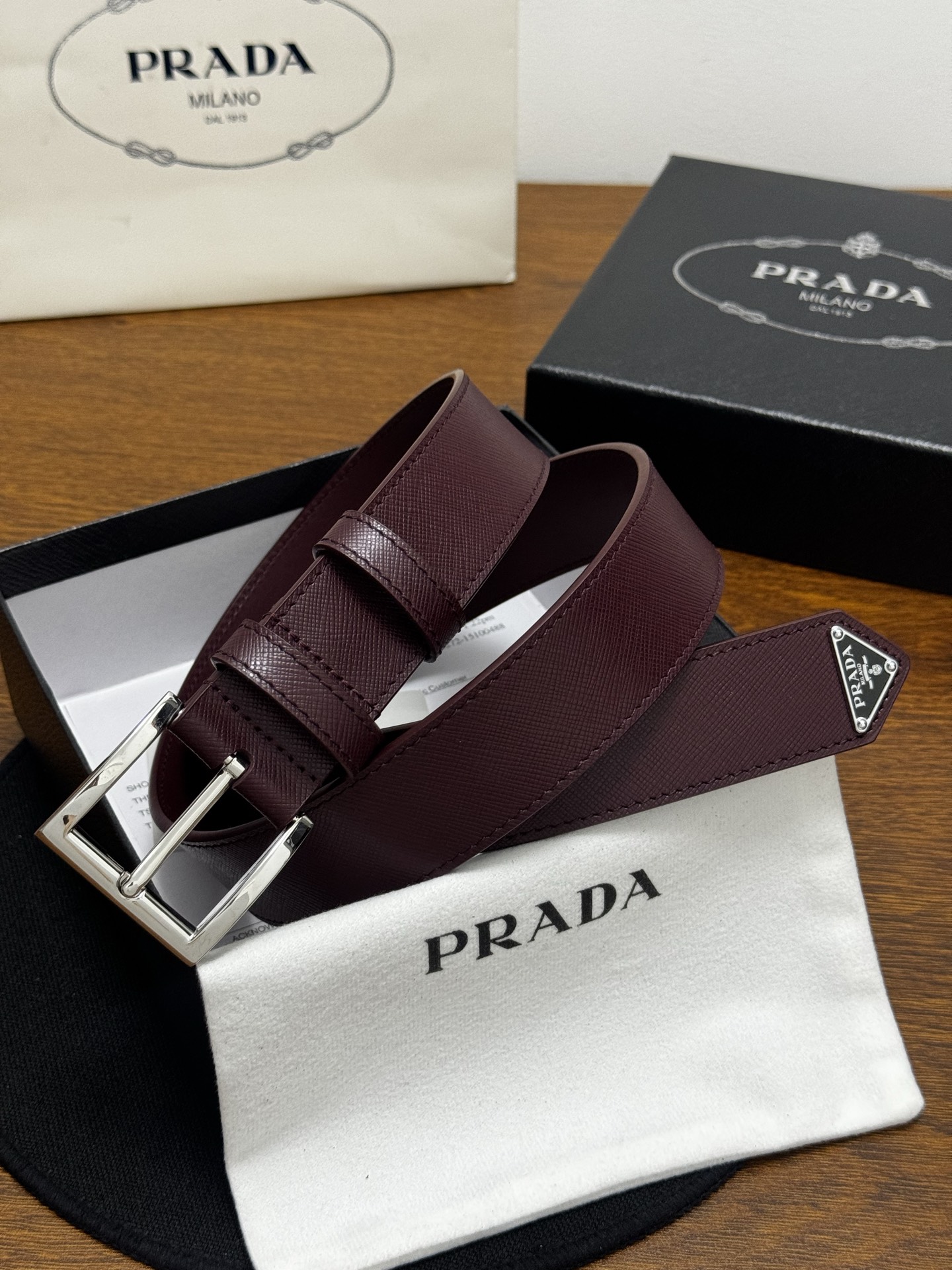 PRADA   3.5cm     枣红Saffiano牛皮革腰带设计简约精致，饰有标志性的涂珐琅三角形