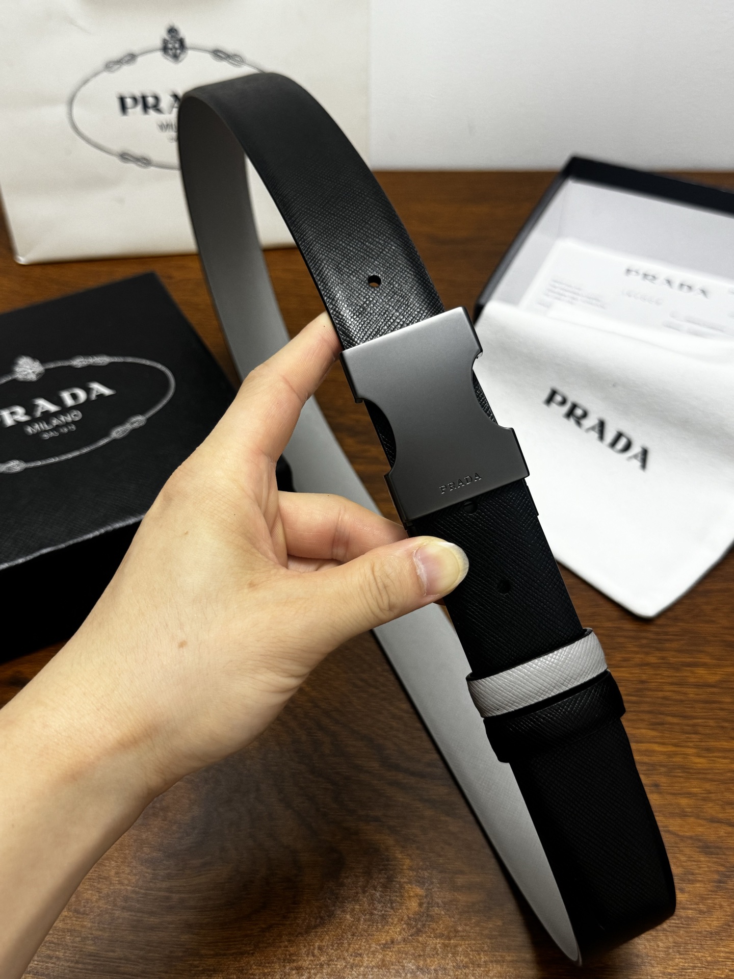 PRADA   3.5cm     黑/灰   砂枪扣 十字纹牛皮革腰带设计简约精致，亮眼的金属铜质工艺扣头。柔软自然，