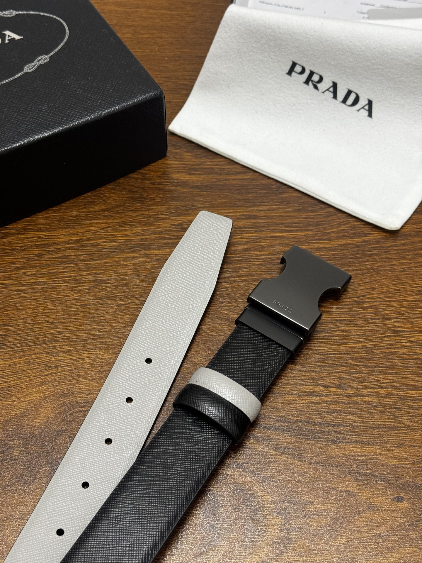 PRADA   3.5cm     黑/灰   砂枪扣 十字纹牛皮革腰带设计简约精致，亮眼的金属铜质工艺扣头。柔软自然，