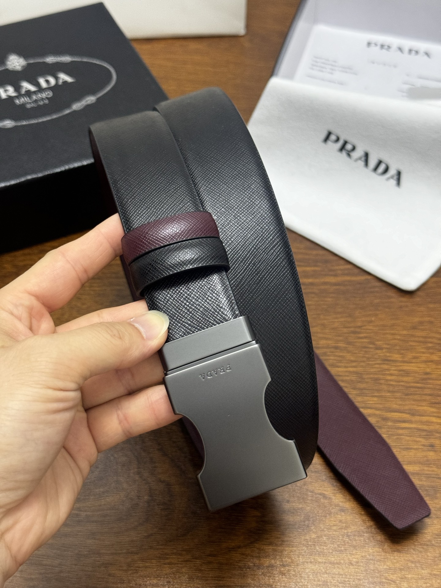 PRADA 3.5cm 黑/枣红 砂枪扣 十字纹牛皮革腰带设计简约精致,亮眼的金属铜质工艺扣头。柔软自然 PRADA 3.5cm 黑/枣红 砂枪扣 十字纹牛皮革腰带设计简约精致,亮眼的金属铜质工艺扣头。柔软自然