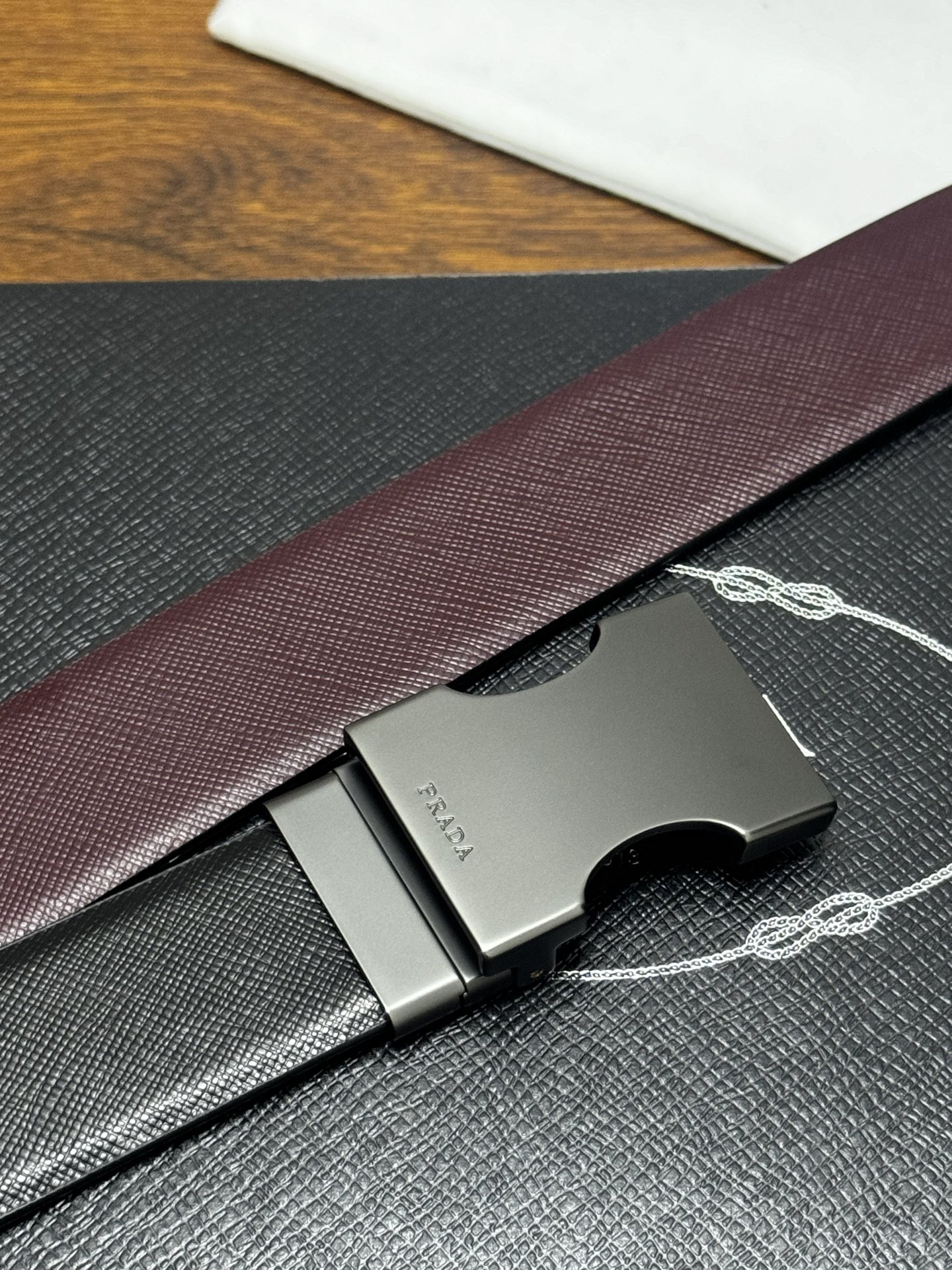 PRADA 3.5cm 黑/枣红 砂枪扣 十字纹牛皮革腰带设计简约精致,亮眼的金属铜质工艺扣头。柔软自然 PRADA 3.5cm 黑/枣红 砂枪扣 十字纹牛皮革腰带设计简约精致,亮眼的金属铜质工艺扣头。柔软自然