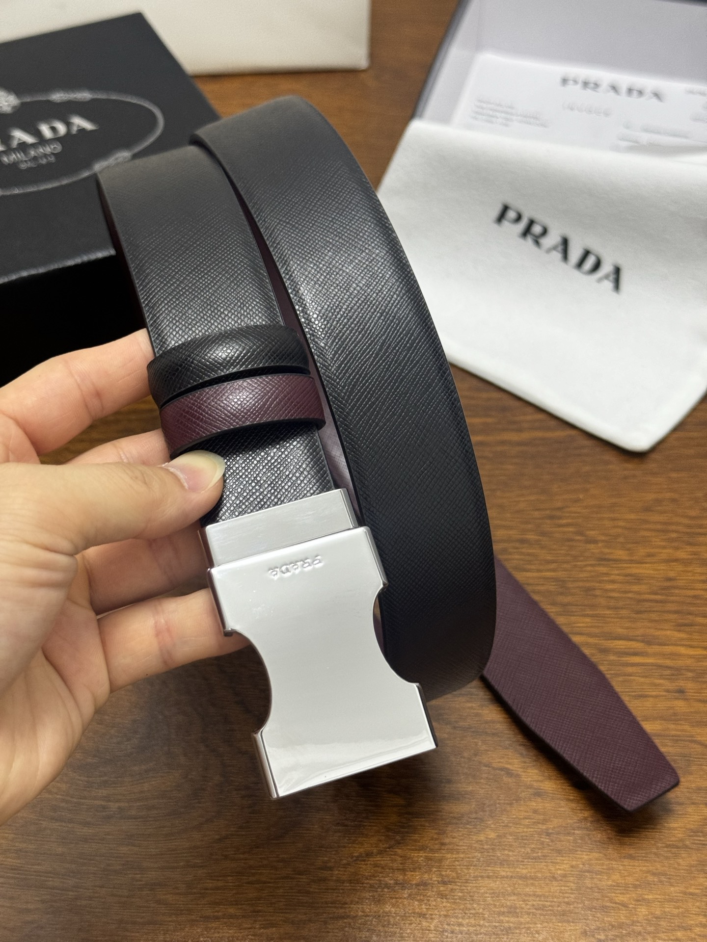 PRADA   3.5cm     黑/枣红   亮银扣 十字纹牛皮革腰带设计简约精致，亮眼的金属铜质工艺扣头。柔软自然