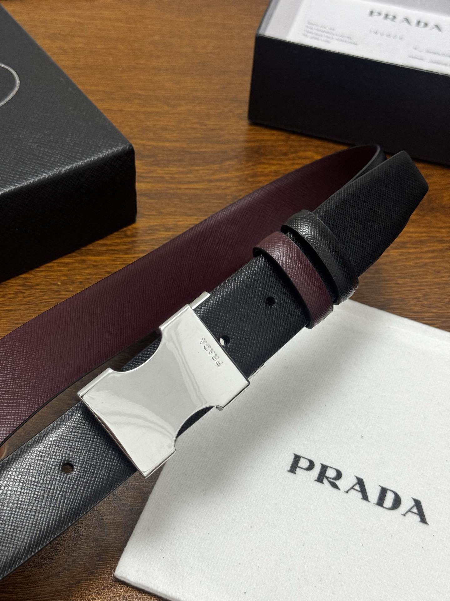 PRADA   3.5cm     黑/枣红   亮银扣 十字纹牛皮革腰带设计简约精致，亮眼的金属铜质工艺扣头。柔软自然