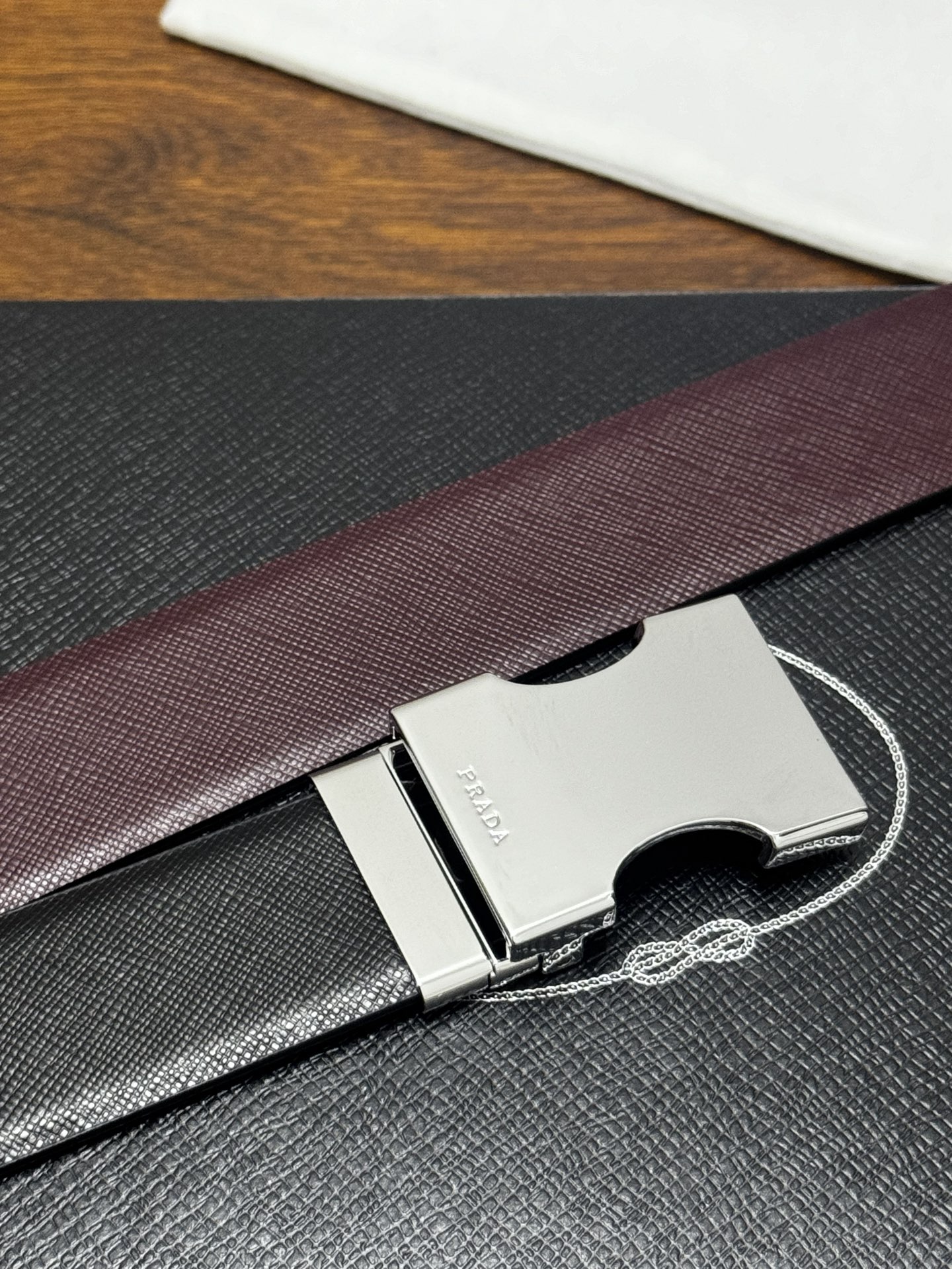 PRADA   3.5cm     黑/枣红   亮银扣 十字纹牛皮革腰带设计简约精致，亮眼的金属铜质工艺扣头。柔软自然