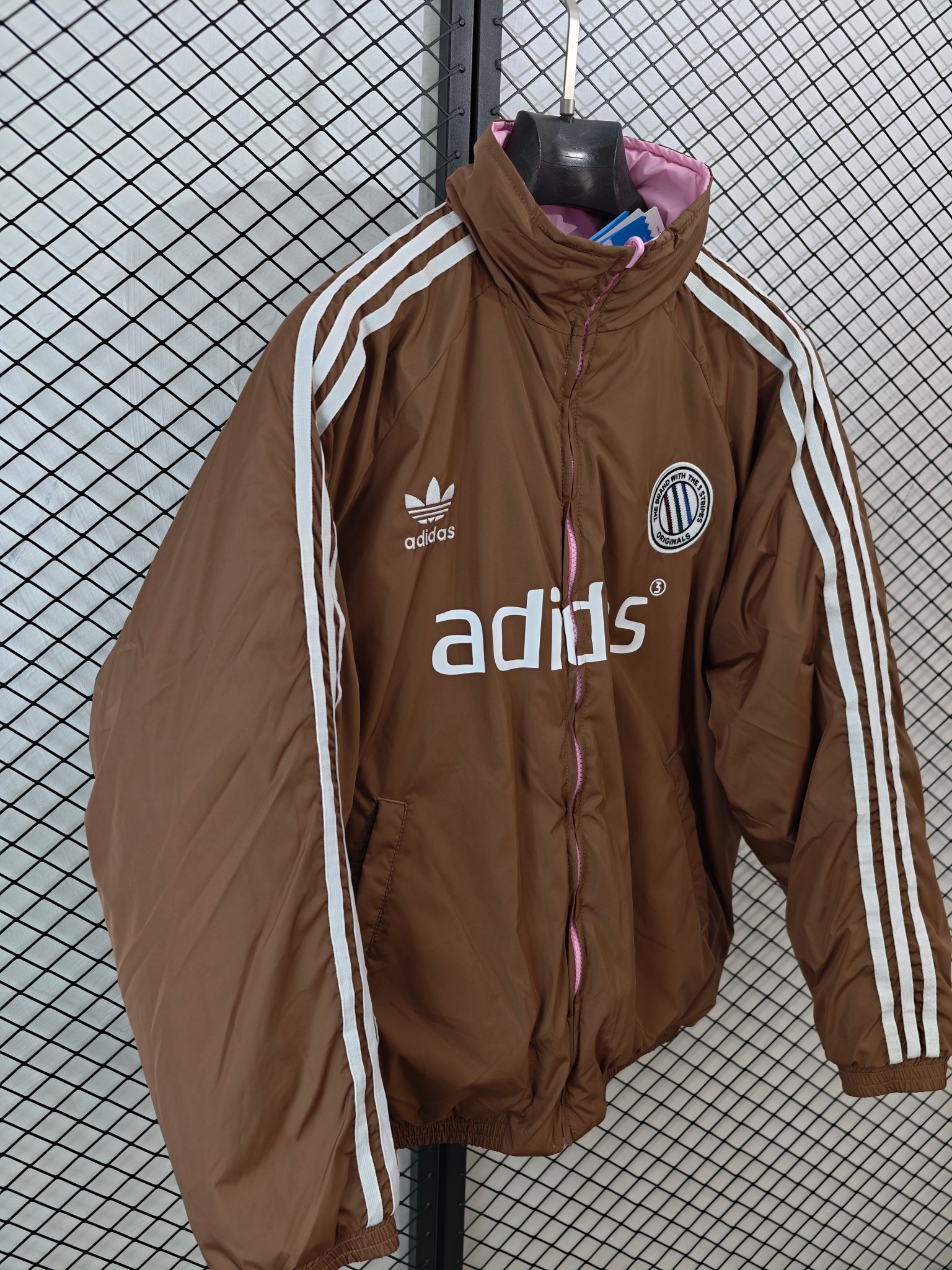 💰185
【Adidas Originals | ADCREV PAD TT】
复古双面穿棉服· 条纹Logo · 宽松版型

● 核心工艺：采用双面可穿设计，实现一衣多穿的功能性；衣身饰有经典条纹Logo，延续品牌复古运动基因。
●甄选材质：面料注重保暖性与舒适度，内部填充提供良好保暖效果；细节处配备全套原版辅料，确保品质。
●包容版型：宽松剪裁，男女同款，适配多种身形，打造慵懒复古的街头风格。

尺码参考
M/ L / XL / XXL
（建议补充具体尺码数据，例如以厘米为单位的衣长、胸围等，以供参考）

配色
深棕粉色

#AdidasOriginals #双面穿棉服 #复古运动 #男女同款