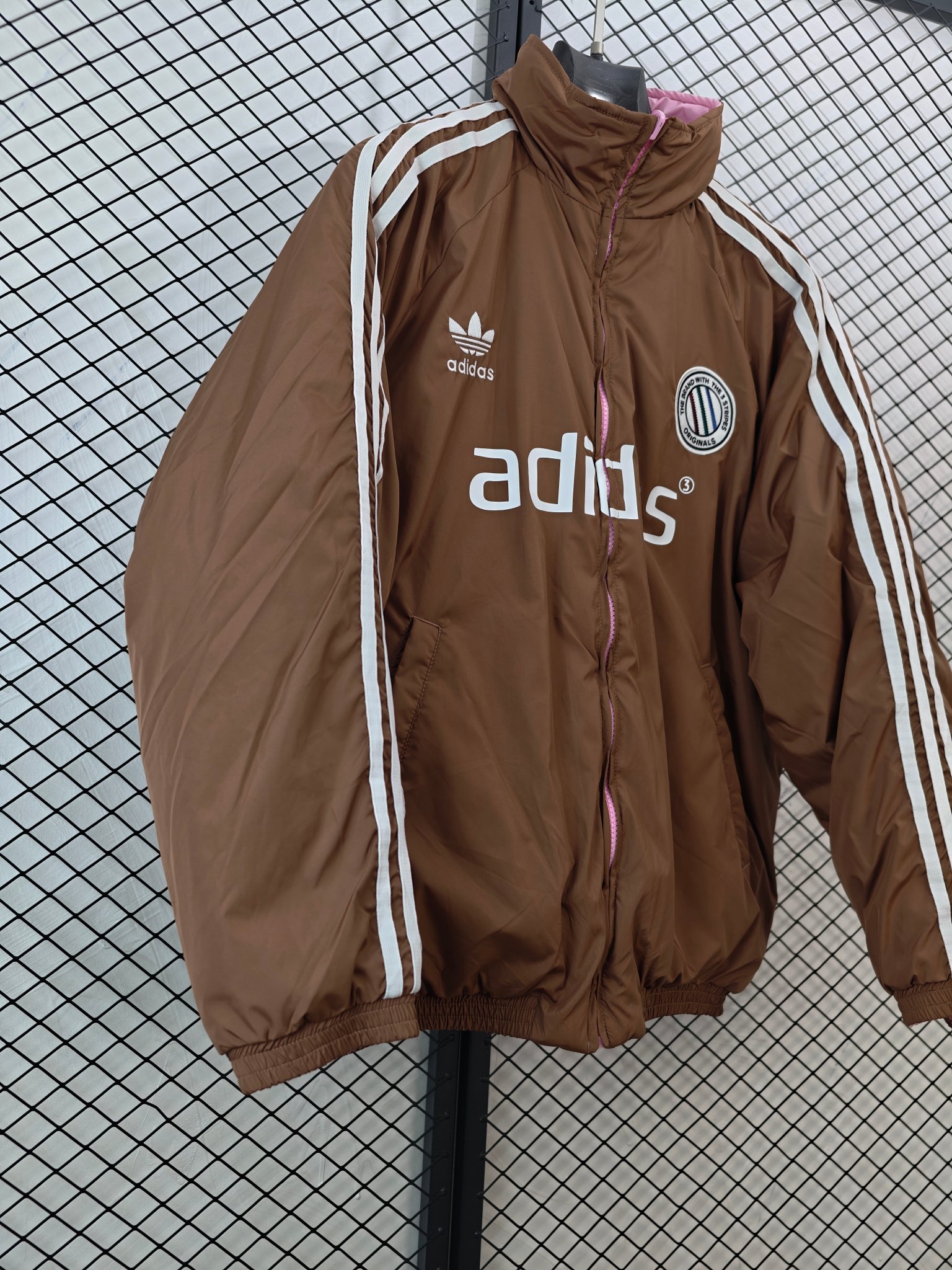 💰185
【Adidas Originals | ADCREV PAD TT】
复古双面穿棉服· 条纹Logo · 宽松版型

● 核心工艺：采用双面可穿设计，实现一衣多穿的功能性；衣身饰有经典条纹Logo，延续品牌复古运动基因。
●甄选材质：面料注重保暖性与舒适度，内部填充提供良好保暖效果；细节处配备全套原版辅料，确保品质。
●包容版型：宽松剪裁，男女同款，适配多种身形，打造慵懒复古的街头风格。

尺码参考
M/ L / XL / XXL
（建议补充具体尺码数据，例如以厘米为单位的衣长、胸围等，以供参考）

配色
深棕粉色

#AdidasOriginals #双面穿棉服 #复古运动 #男女同款